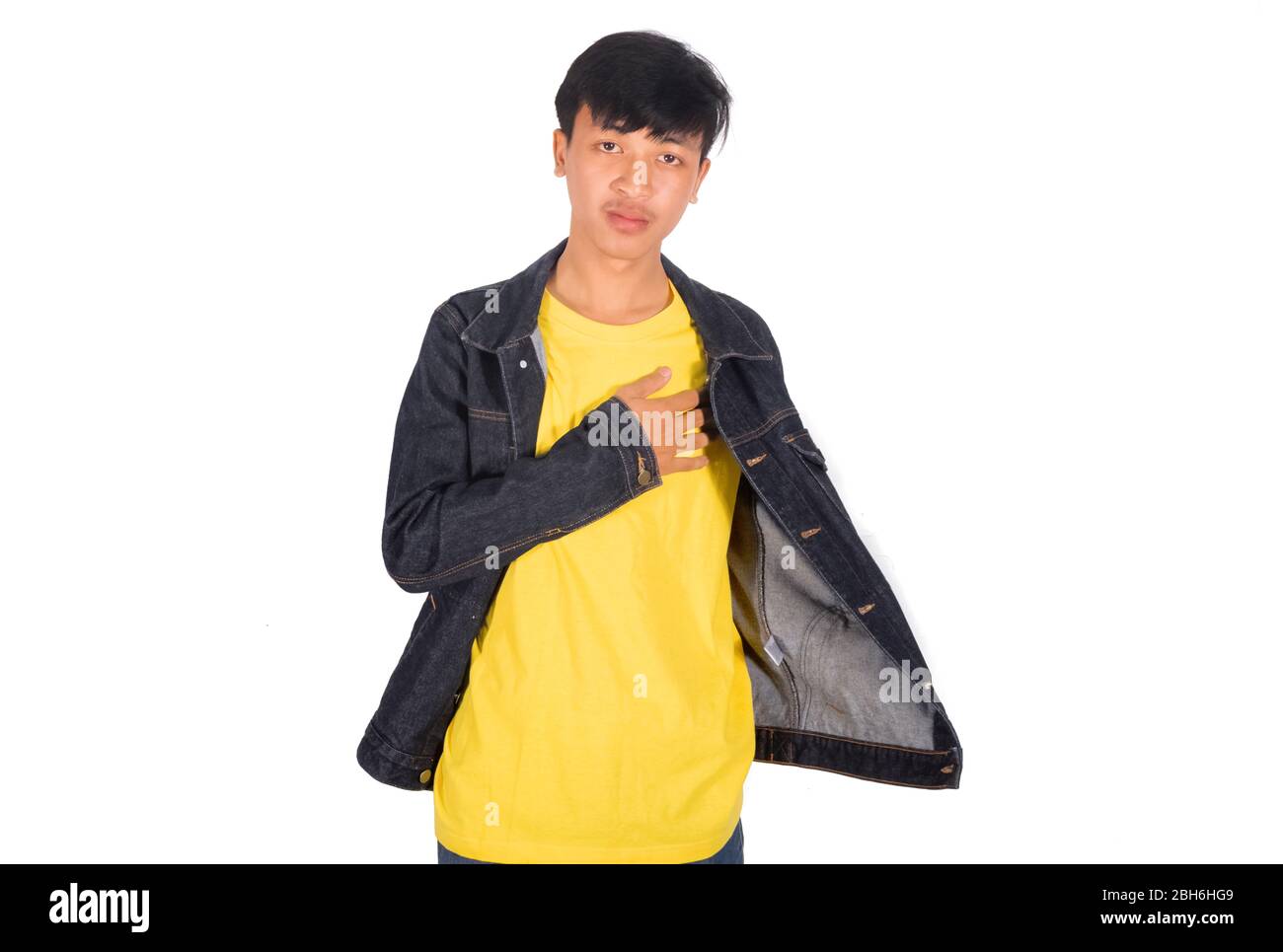 La foto del hombre asiático muestra la camisa amarilla bajo su chaqueta y  toca su posición del corazón Fotografía de stock - Alamy