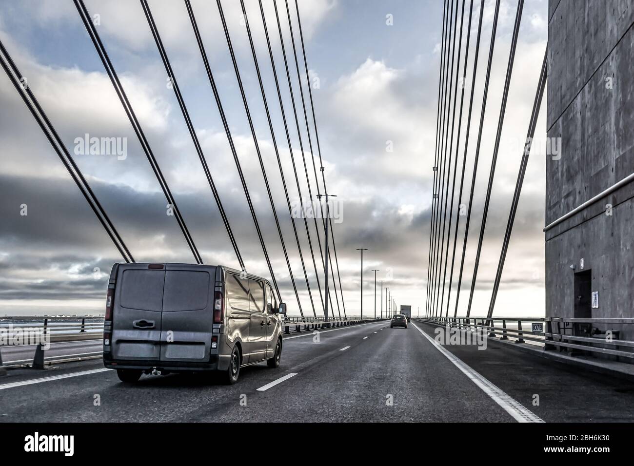 Una furgoneta negra espeluznante y otros coches que conducen sobre el puente colgante a Suecia, 17 de diciembre de 2017 Foto de stock