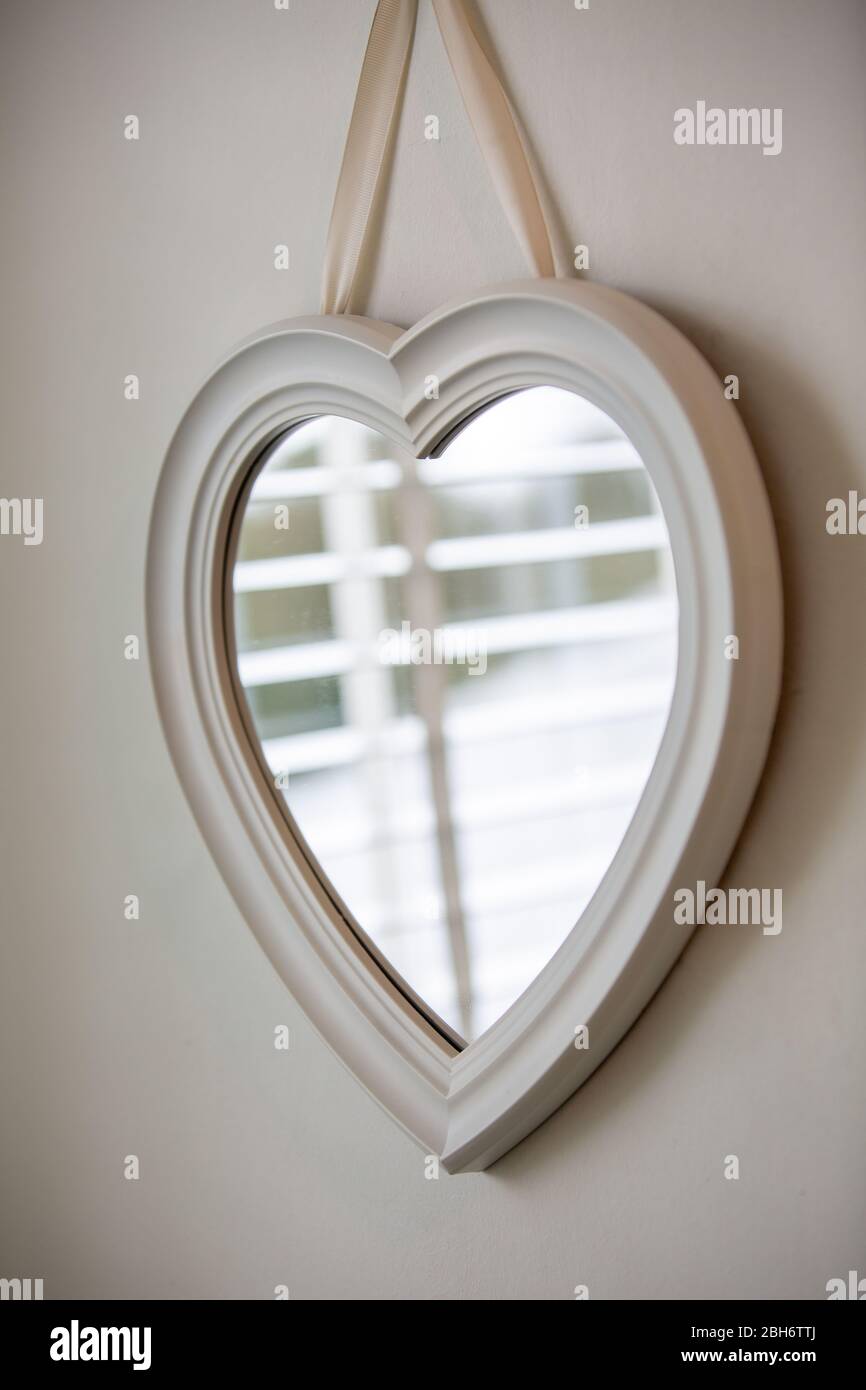 espejo en forma de corazón colgado en una pared Fotografía de stock - Alamy