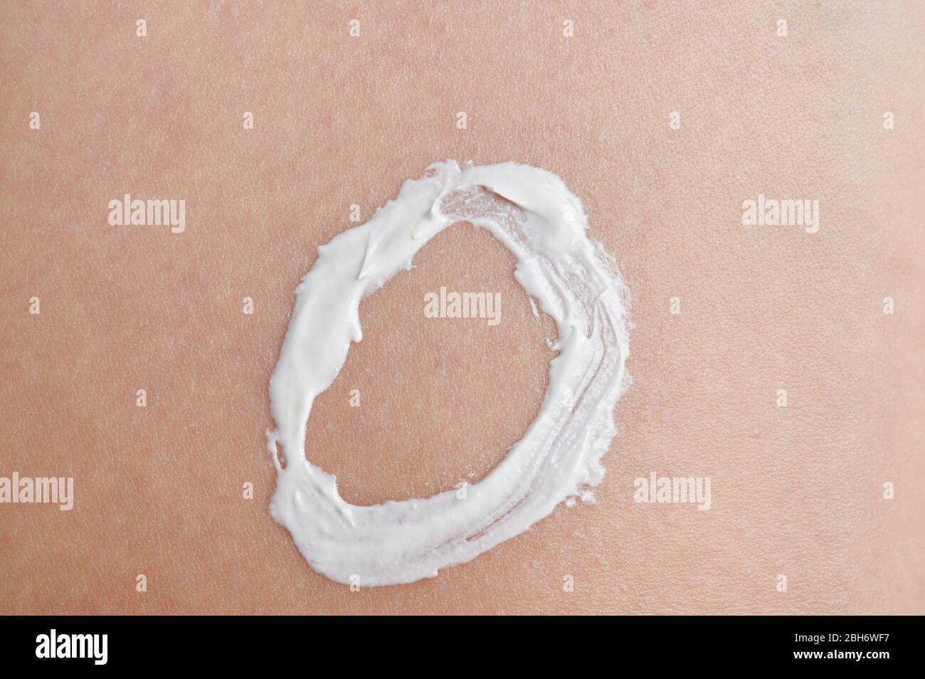 Tema de protección de la piel del bebé. Forma circular de crema blanca para la piel Foto de stock