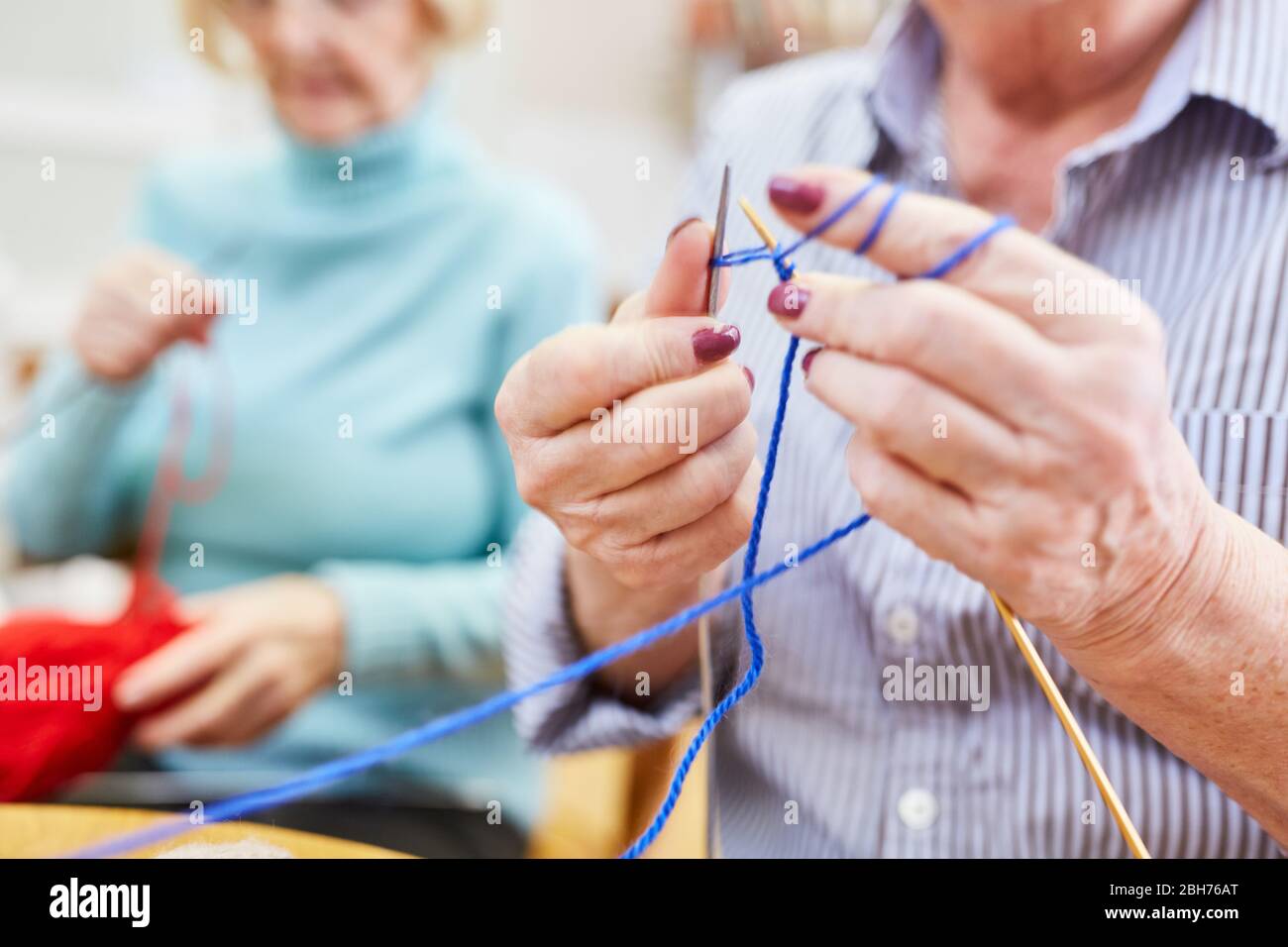 Los ancianos aprenden a ganchillo o a coser en un club de tejer o taller de artesanía Foto de stock