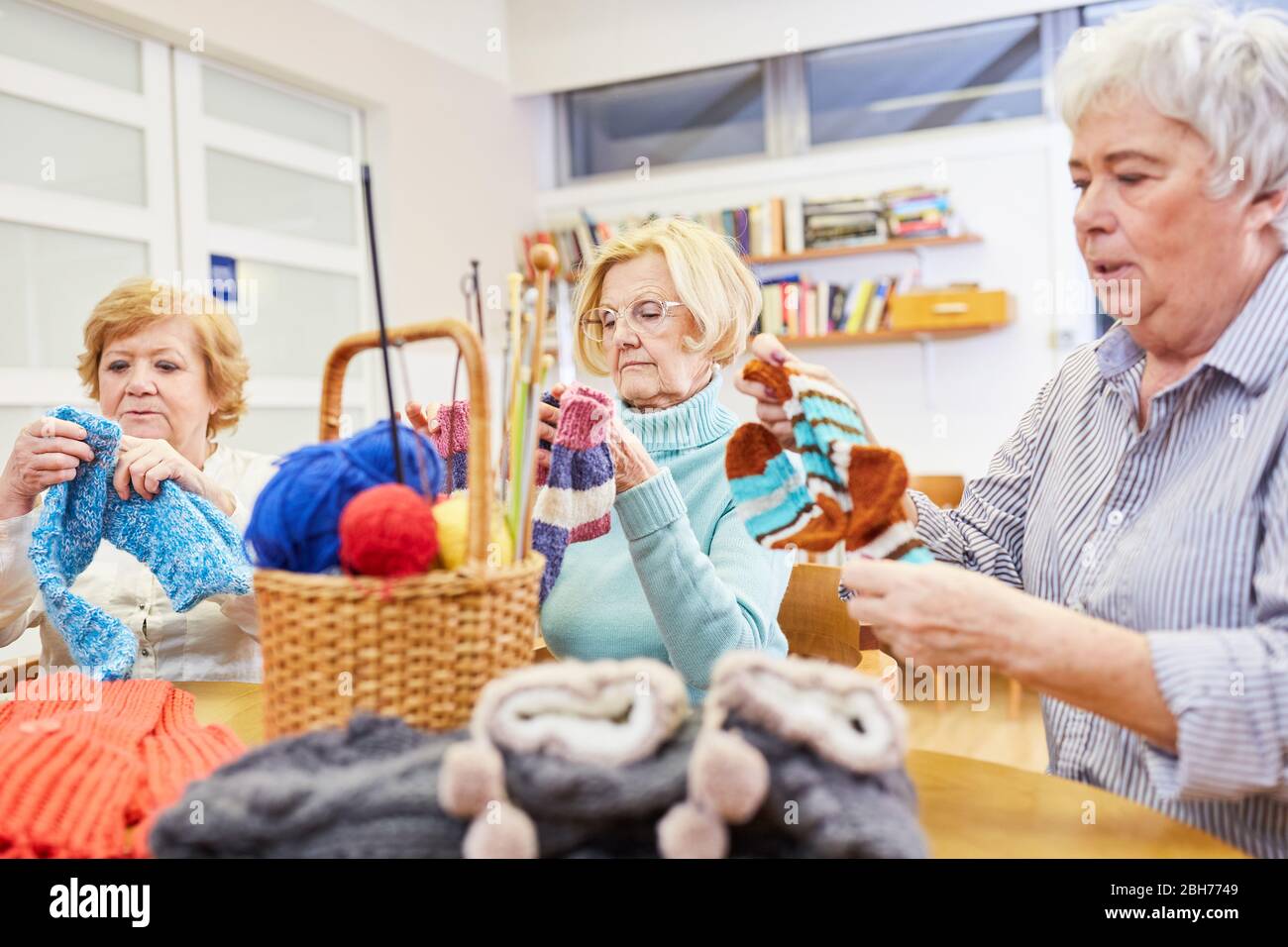 Grupo de mujeres ancianas crocheting en un taller de artesanía en el hogar de jubilación Foto de stock