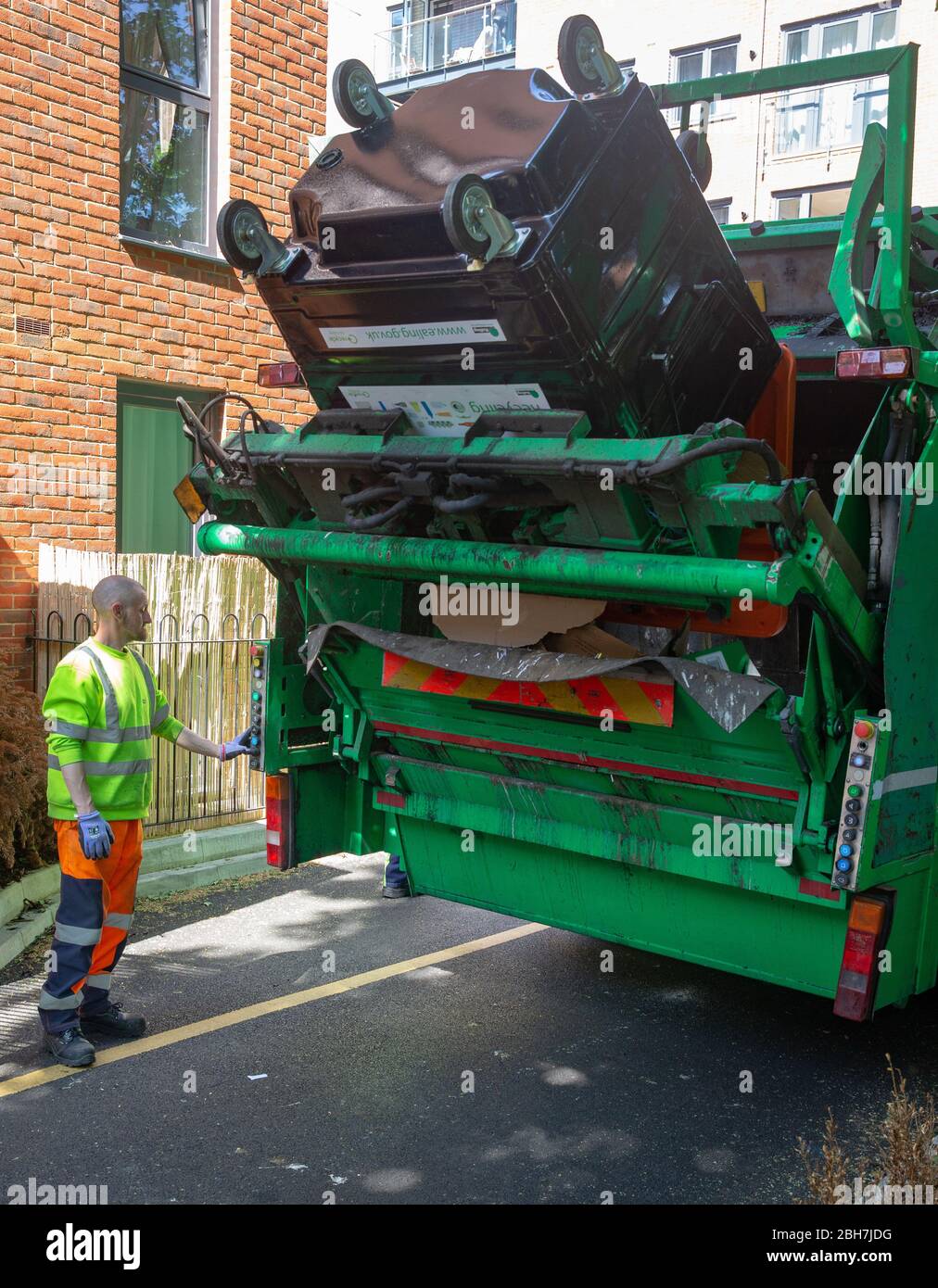 Reciclaje camiones y trabajadores clave recoger y vaciar los contenedores durante el período de cierre. Hay un aumento en el reciclaje como la gente consume más en casa Foto de stock