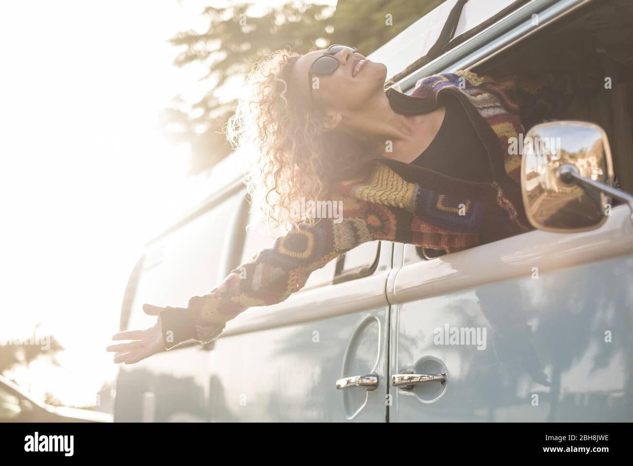 Felicidad y libertad concepto de estilo de vida con hermosa niña joven caucásica mujer fuera del vehículo disfrutando del viento y sentir el aire libre - viaje y vacaciones concepto de transporte para la moda chica Foto de stock