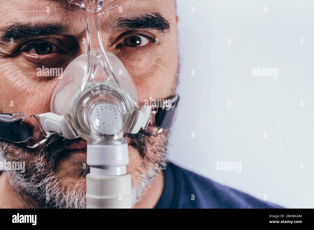 Hombre Asiático Con La Apnea Del Sueño Usando La Máquina De CPAP, Usando La  Máscara De Arnés Que Conecta Al Tubo De Aire, Enfoque Selectivo En El  Hombre Máscara Y El Arnés