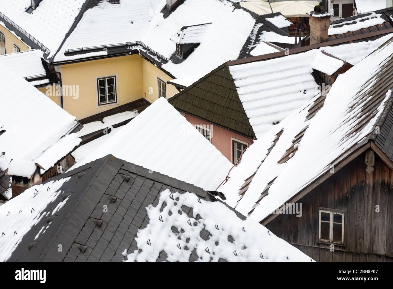 Tejados cubiertos de nieve en el pueblo de Hallstatt, en la región de Salzkammergut, Austria Foto de stock