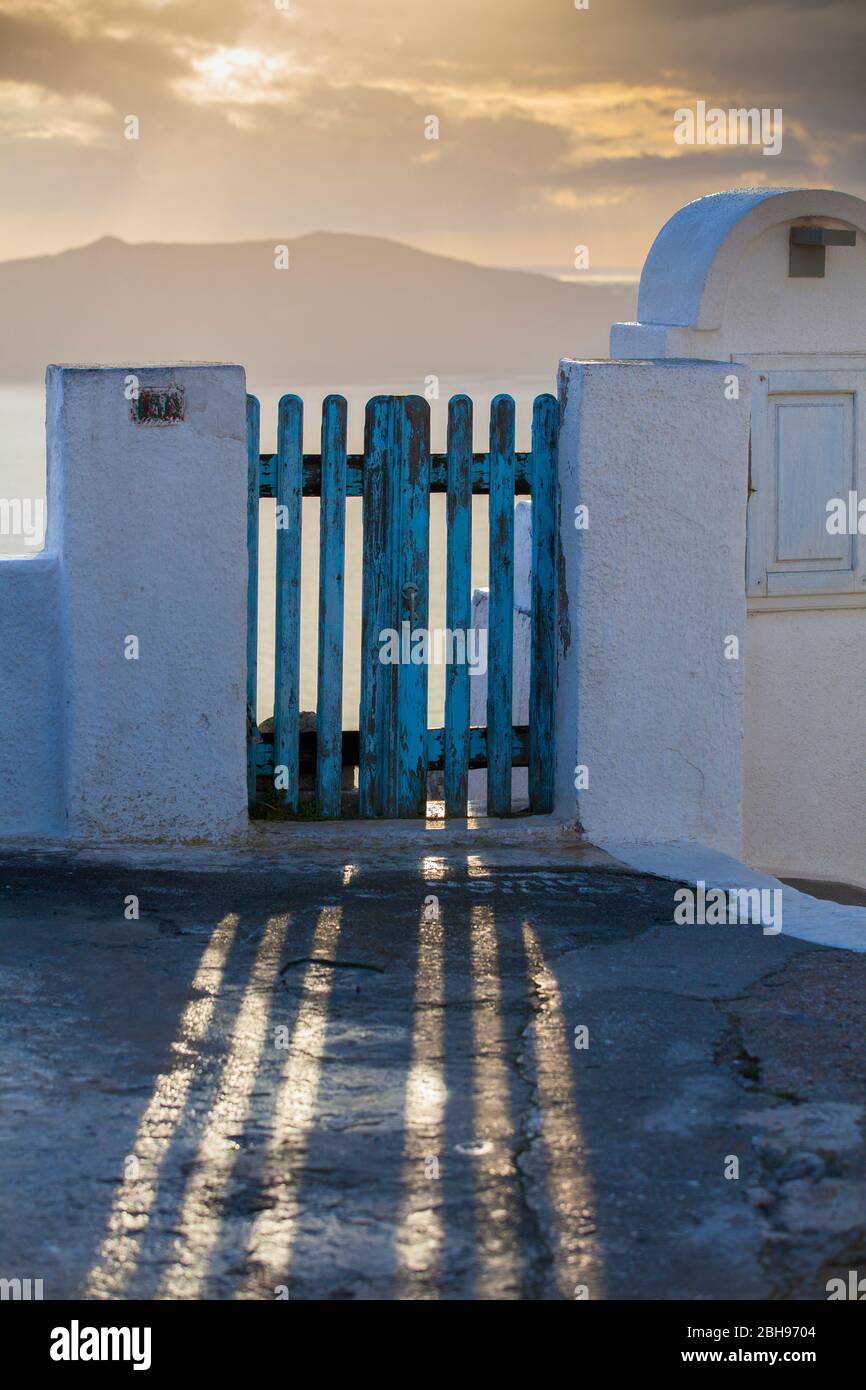 Los rayos de luz caen a través de la rejilla azul de la puerta. Nubes y mar de Santorini, Thira, Cícladas, Grecia, Egeo meridional, Grecia Foto de stock