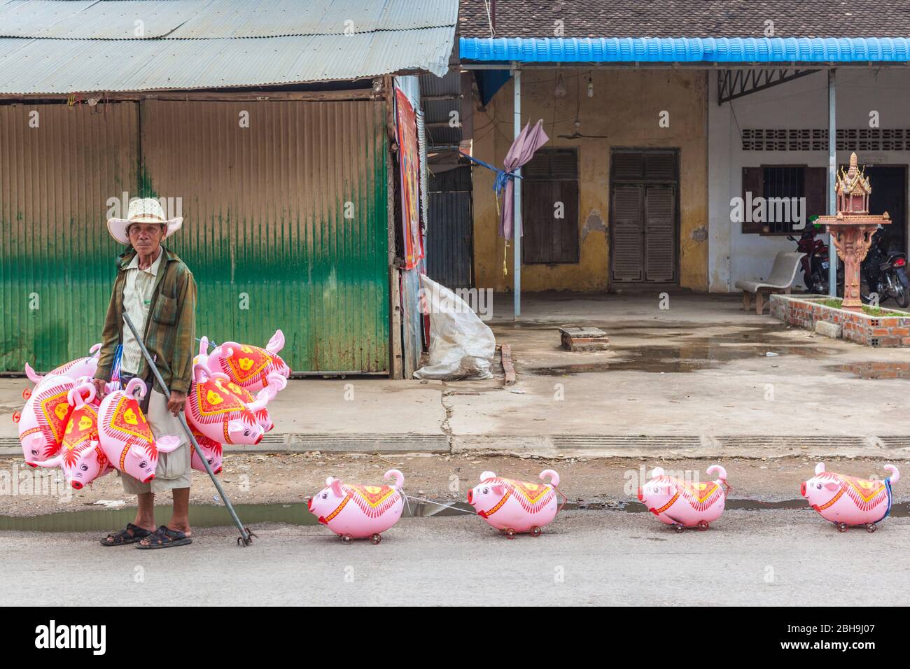 Camboya, Battambang, vendedor con juguetes de tiro en forma de cerdo, sin emisiones Foto de stock