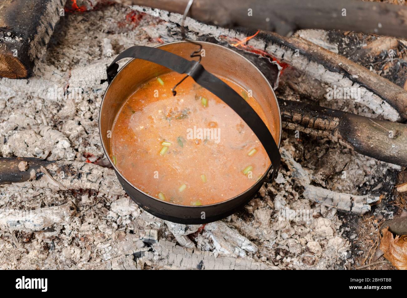 Cocine la sopa de guisantes en la estaca. Sopa Buryak en un caldero en la estaca. Arriba. Foto de stock
