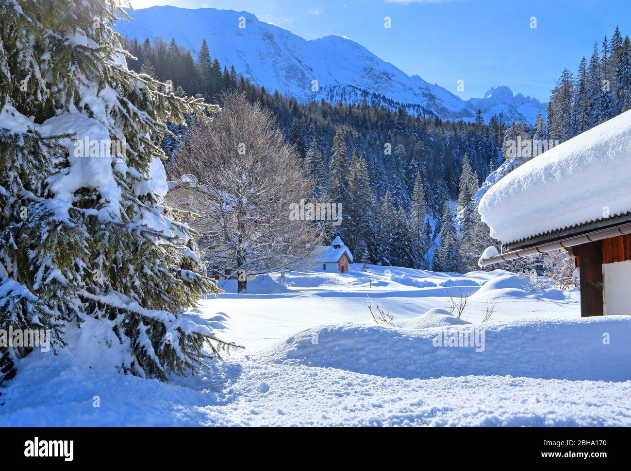 Casas de nieve profunda contra las montañas Wetterstein, en Elmau, cerca de Klais, tierra de Werdenfelser, Alta Baviera, Baviera, Alemania Foto de stock