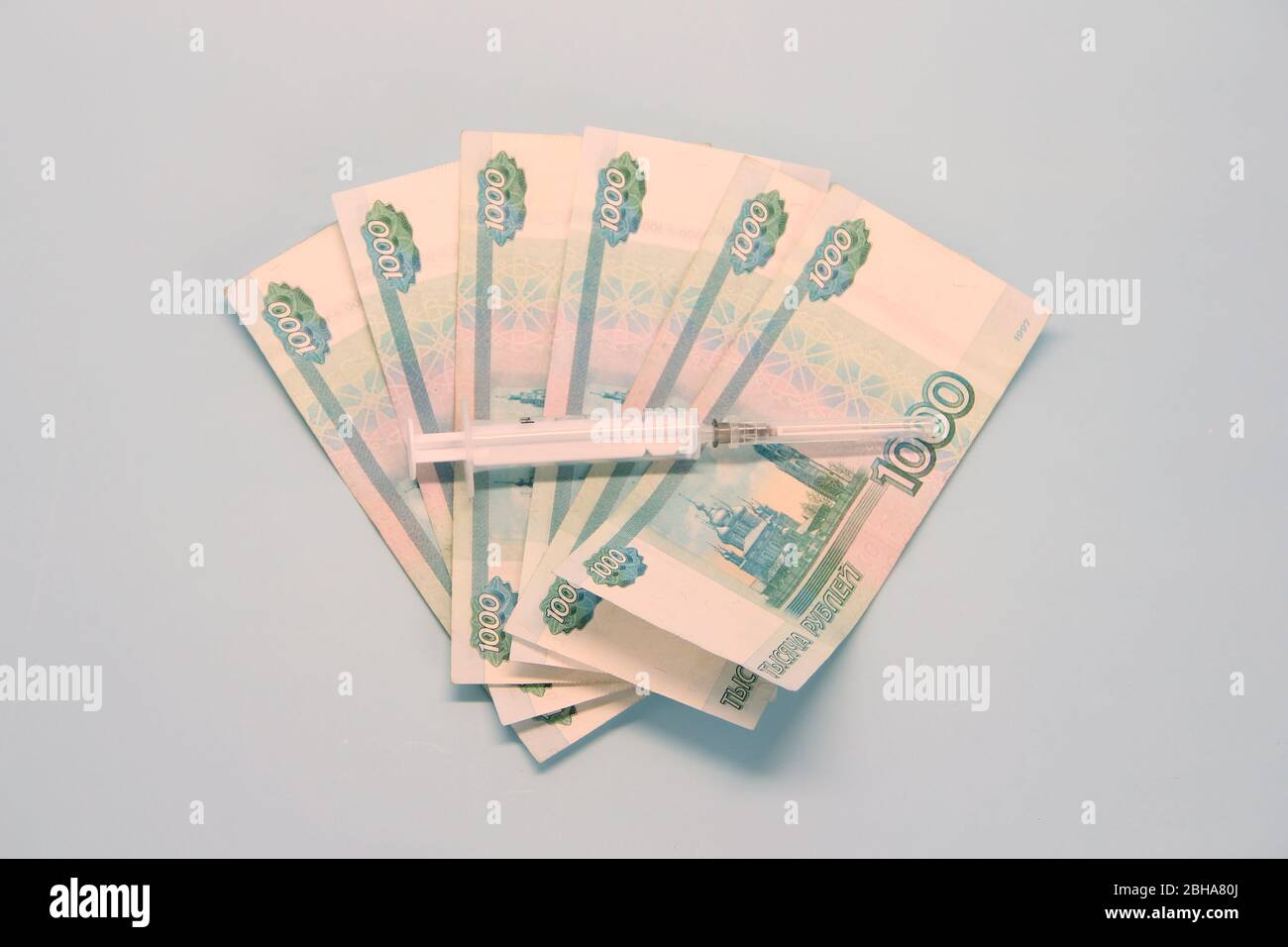 Billetes de papel moneda rusos de mil rublos denominados en un fan. Termómetro acostado encima. Foto de stock