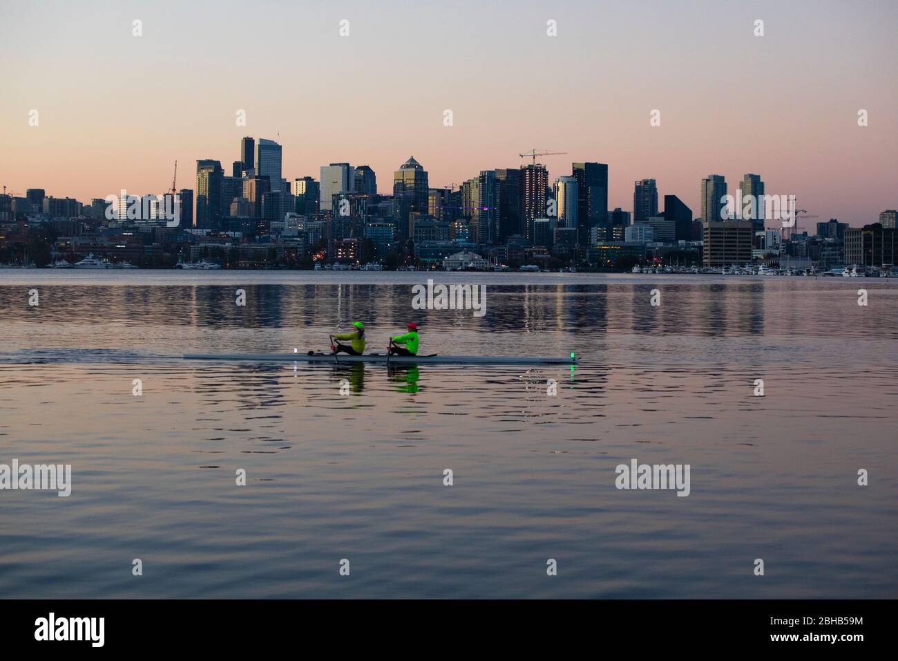 Dos personas en kayak al atardecer con el horizonte de la ciudad en el fondo, Seattle, Washington, EE.UU. Foto de stock
