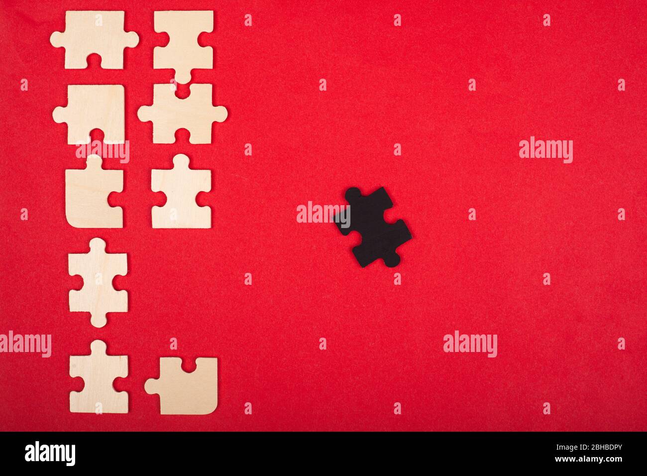 puzzles de madera de color blanco y negro sobre una vista superior de fondo rojo. destacar, líder. Foto de stock