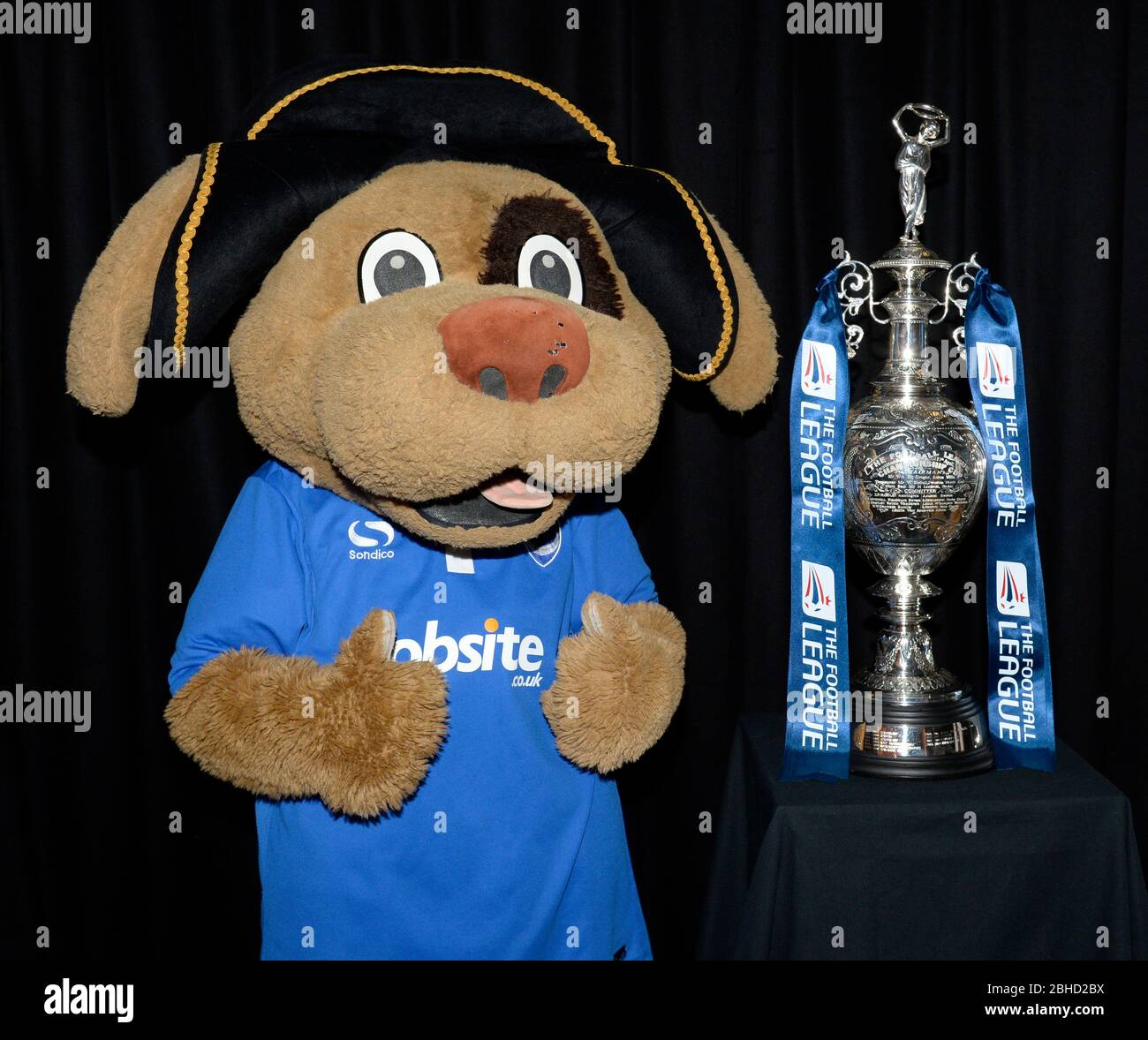 La mascota del club de fútbol de Portsmouth 'Nelson' posee el trofeo del Campeonato de la Liga de Fútbol Inglesa Foto de stock
