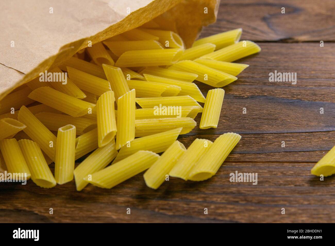 Pasta pene Lisce en una bolsa de papel artesanal sobre una mesa de madera  Fotografía de stock - Alamy