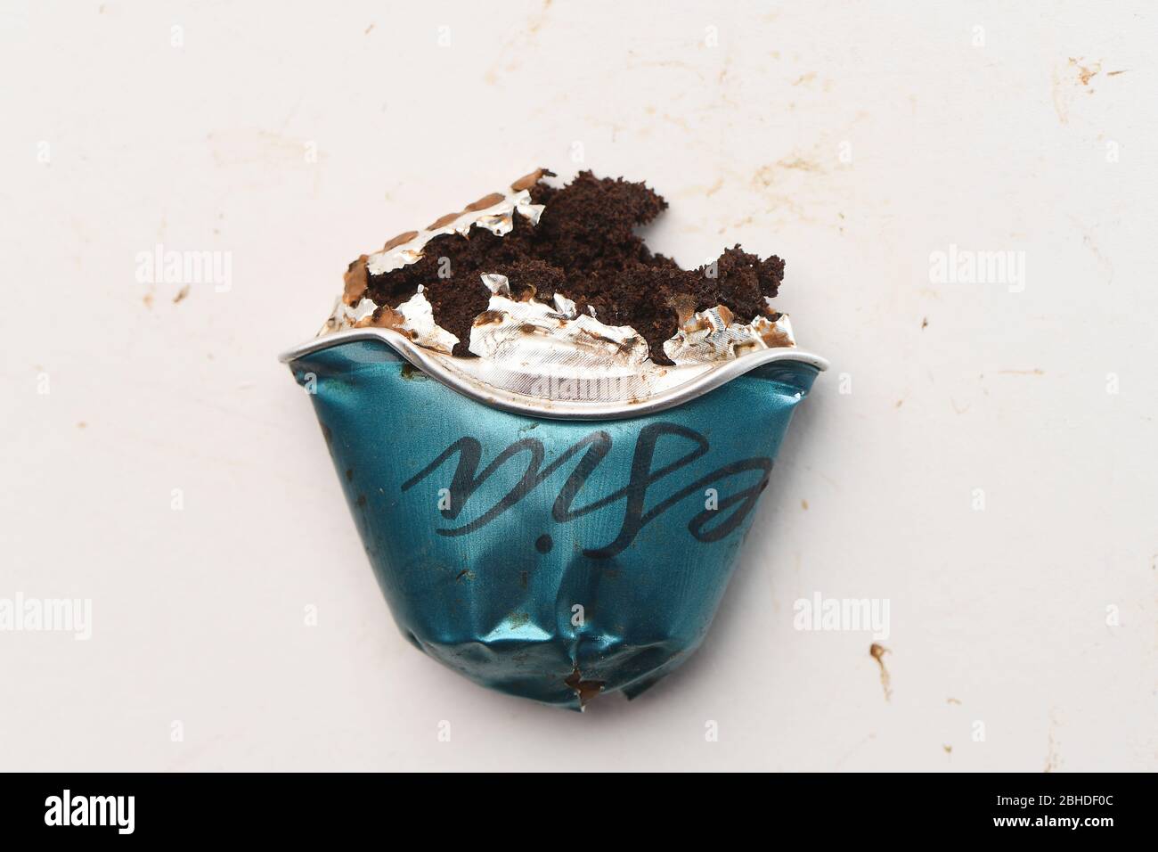 Un primer plano de una cápsula Nespresso triturada para que el café salga  de la cápsula de aluminio sobre un fondo blanco Fotografía de stock - Alamy