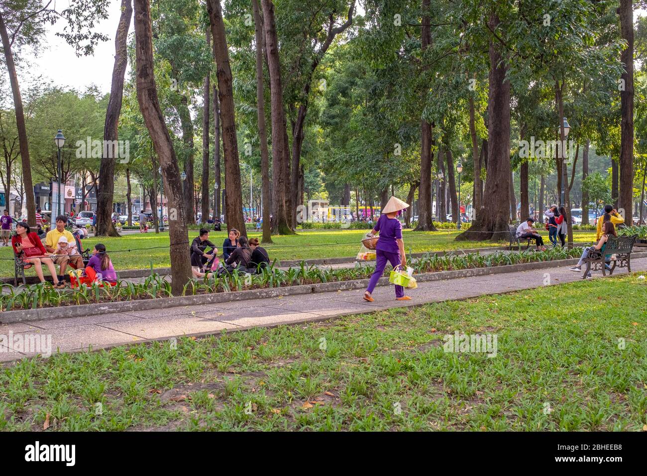 Ciudad Ho Chi Minh, Vietnam - 7 de abril de 2018: Varios lugareños están disfrutando paseando y sentados en un parque a última hora de la tarde Foto de stock