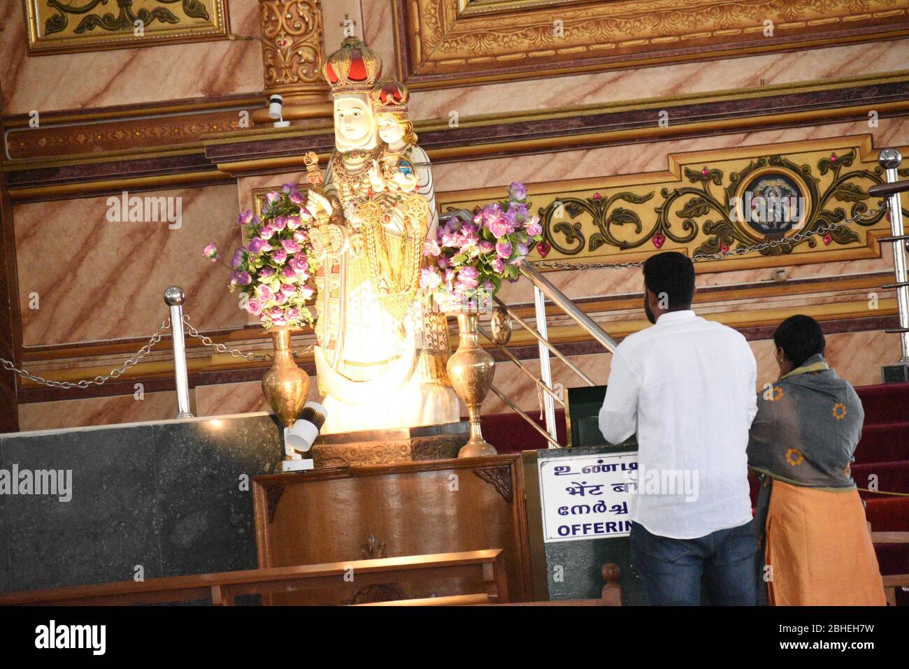 Parejas que oran frente a nuestra estatua de la señora de la salud en la iglesia de Velankanni, también cariñosamente conocida como 'Lourdes del este'. La Basílica de nuestra Señora de Goo Foto de stock