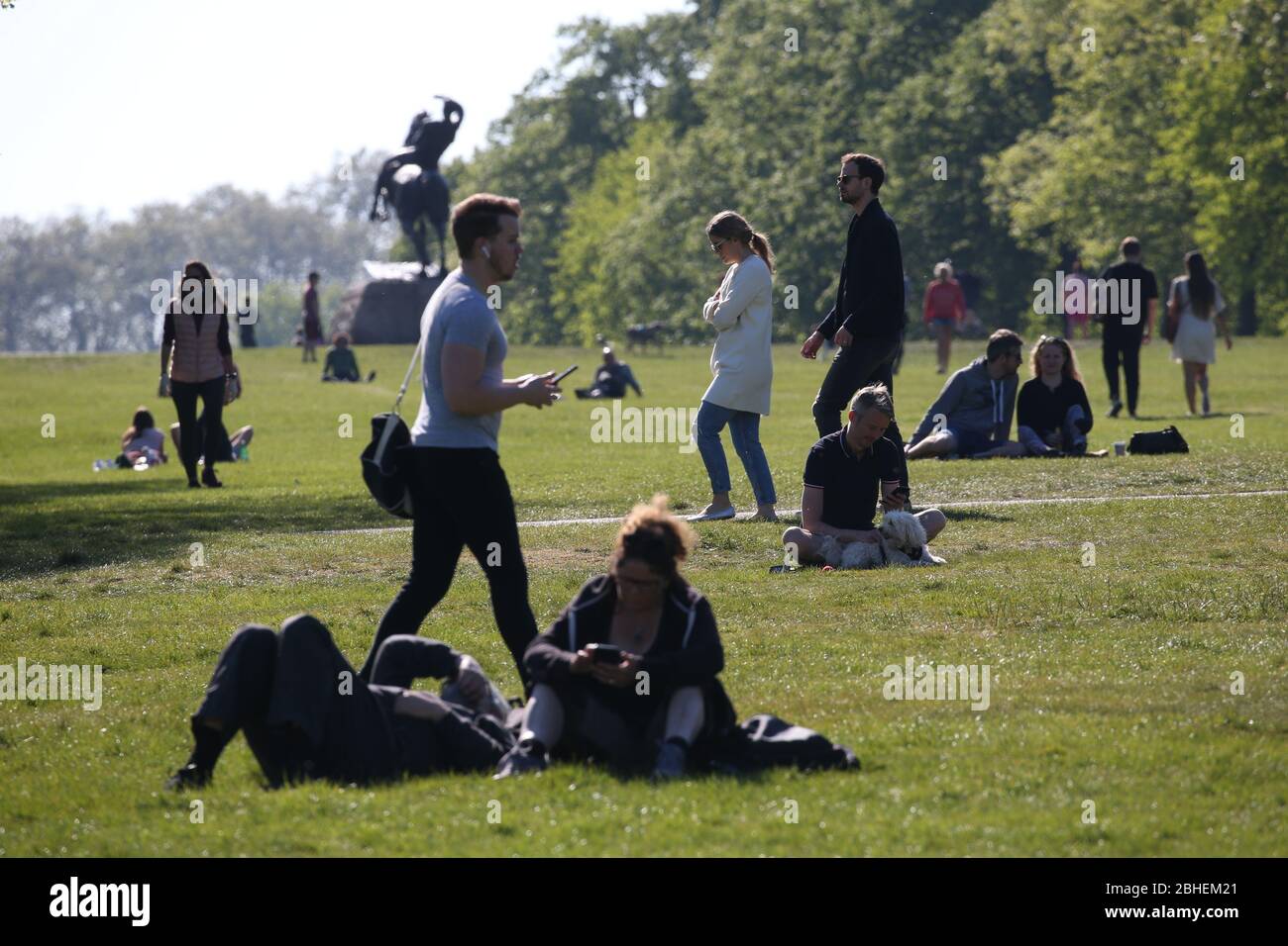 Gente caminando y relajándose en Kensington Gardens, Londres, mientras el Reino Unido continúa en encierro para ayudar a frenar la propagación del coronavirus. Foto PA. Fecha de la foto: Sábado 25 de abril de 2020. Ver historia de PA SALUD Coronavirus. El crédito de la foto debe decir: Jonathan Brady/PA Wire Foto de stock