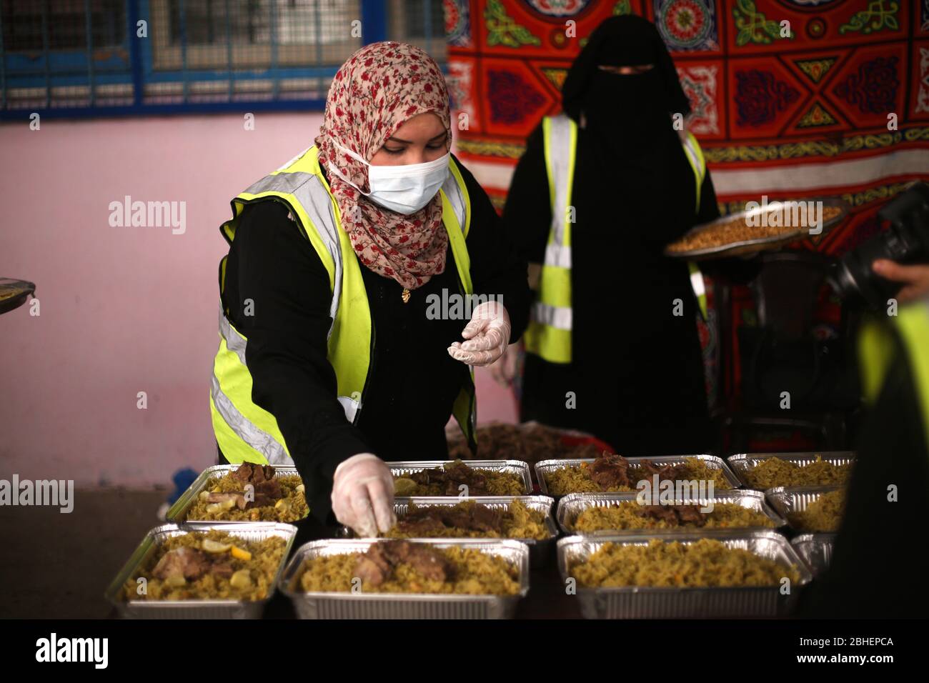 24 de abril de 2020: Gaza, Palestina. 24 de abril de 2020. Las mujeres palestinas preparan alimentos para distribuirlos a los pobres el primer día de Ramadán en la ciudad de Rafah, garantizando una comida fresca a las familias necesitadas en Gaza. La reciente pandemia del Coronavirus y el posterior bloqueo han afectado la situación financiera de muchas familias en la Faja de Gaza, lo que ha perturbado su oportunidad de obtener ingresos en el enclave palestino, ya empobrecido y subbloqueado. Crédito: Samar Abu Eluf/IMAGESLIVE/ZUMA Wire/Alamy Live News Foto de stock
