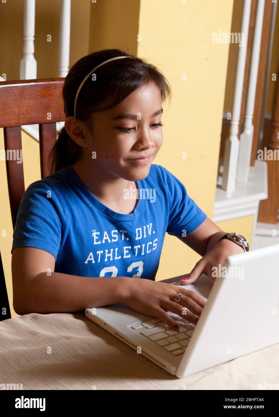 Austin Texas USA, 2012: Una niña japonesa-americana de 10 años usa una computadora portátil mientras se relaja en casa 2012 ©Marjorie Kamys Cotera/Daemmrich Photography Foto de stock
