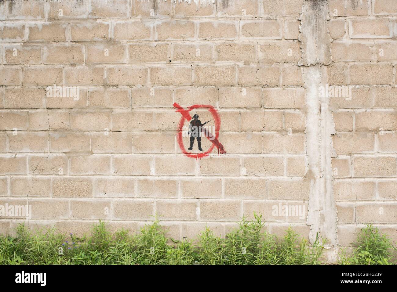 Carmelo, Colonia / Uruguay; 27 de diciembre de 2018: Pared de bloque de concreto con un símbolo pintado: Una silueta de soldado negro tachada de rojo. Foto de stock