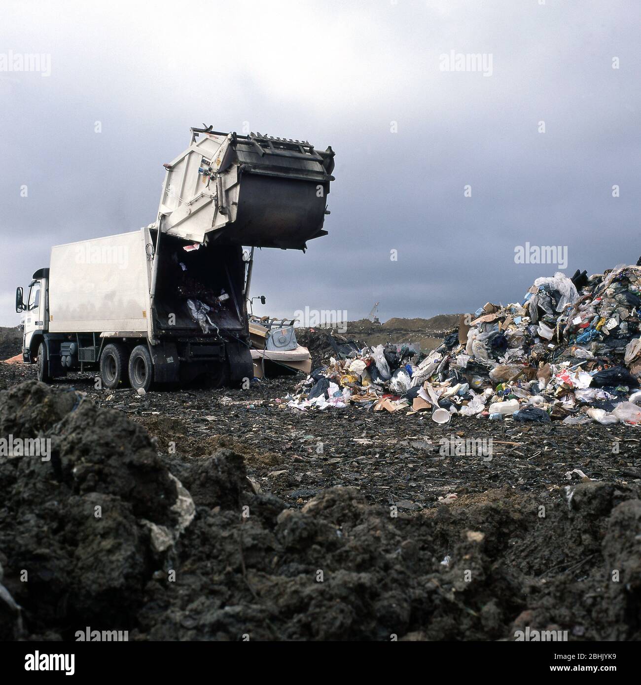 Descargue camiones de basura en un sitio de llenado de tierra. Foto de stock