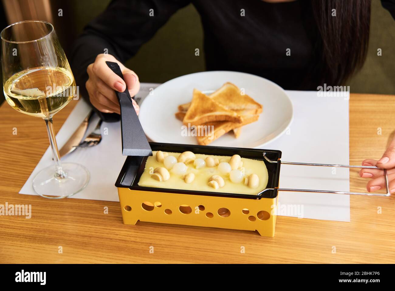 comida suiza. raclette de queso con setas en coupélles pequeño sartén