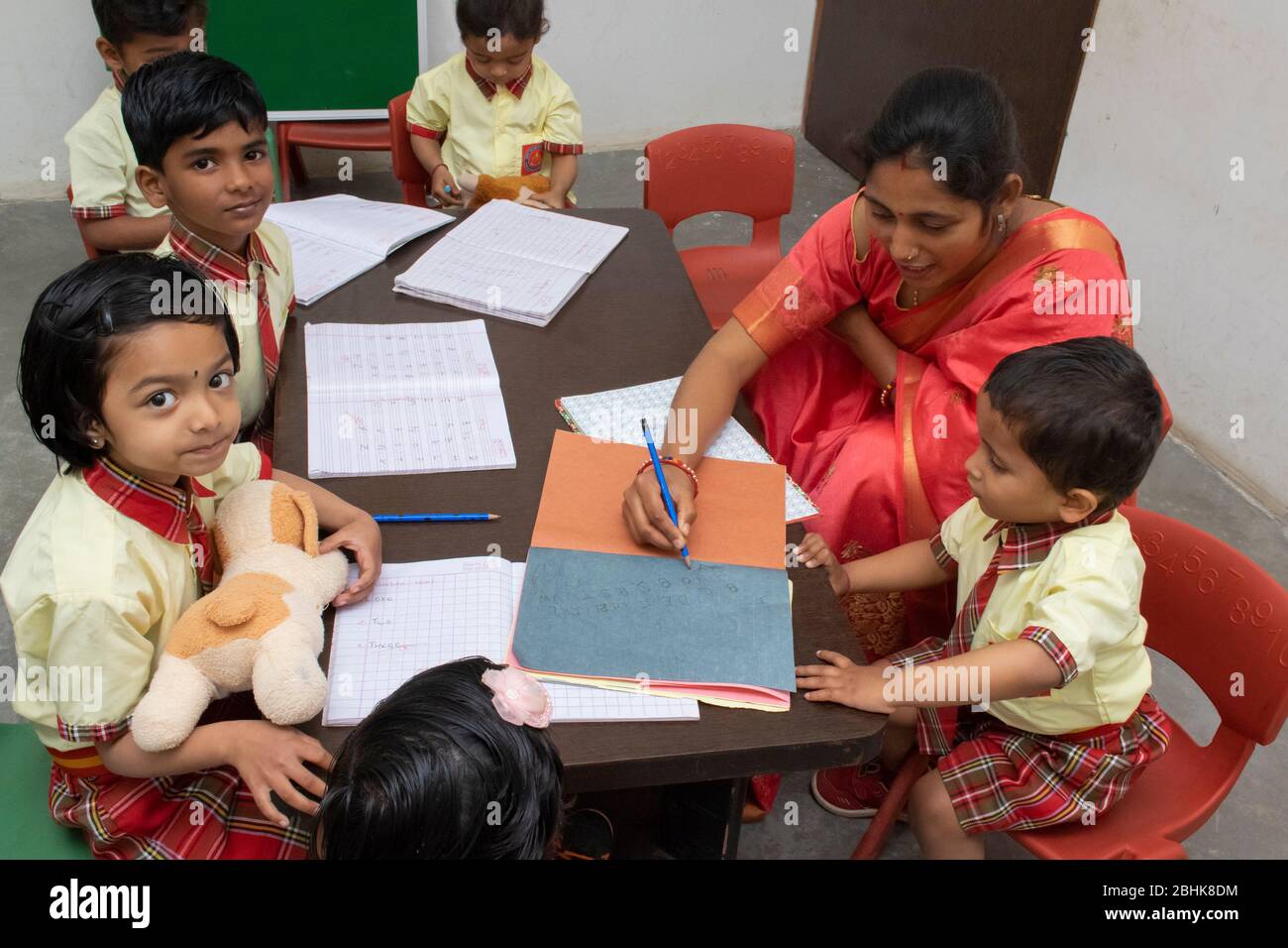 Maestro ayudando a los niños de la escuela primaria en el salón de