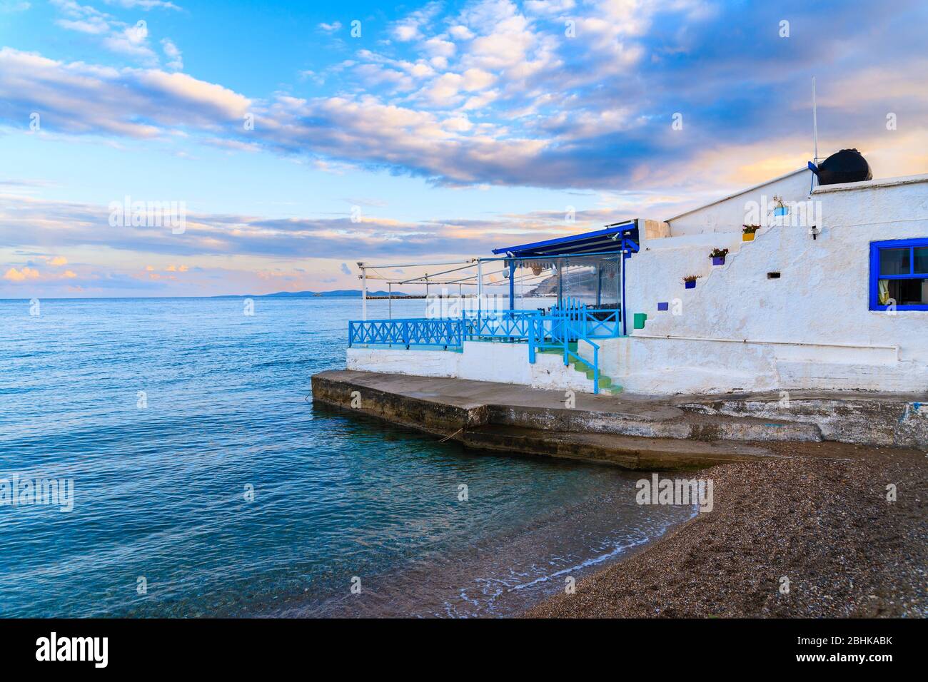 Taberna griega en la playa al atardecer en el pueblo de Ireon, isla de Samos, mar Egeo, Grecia Foto de stock