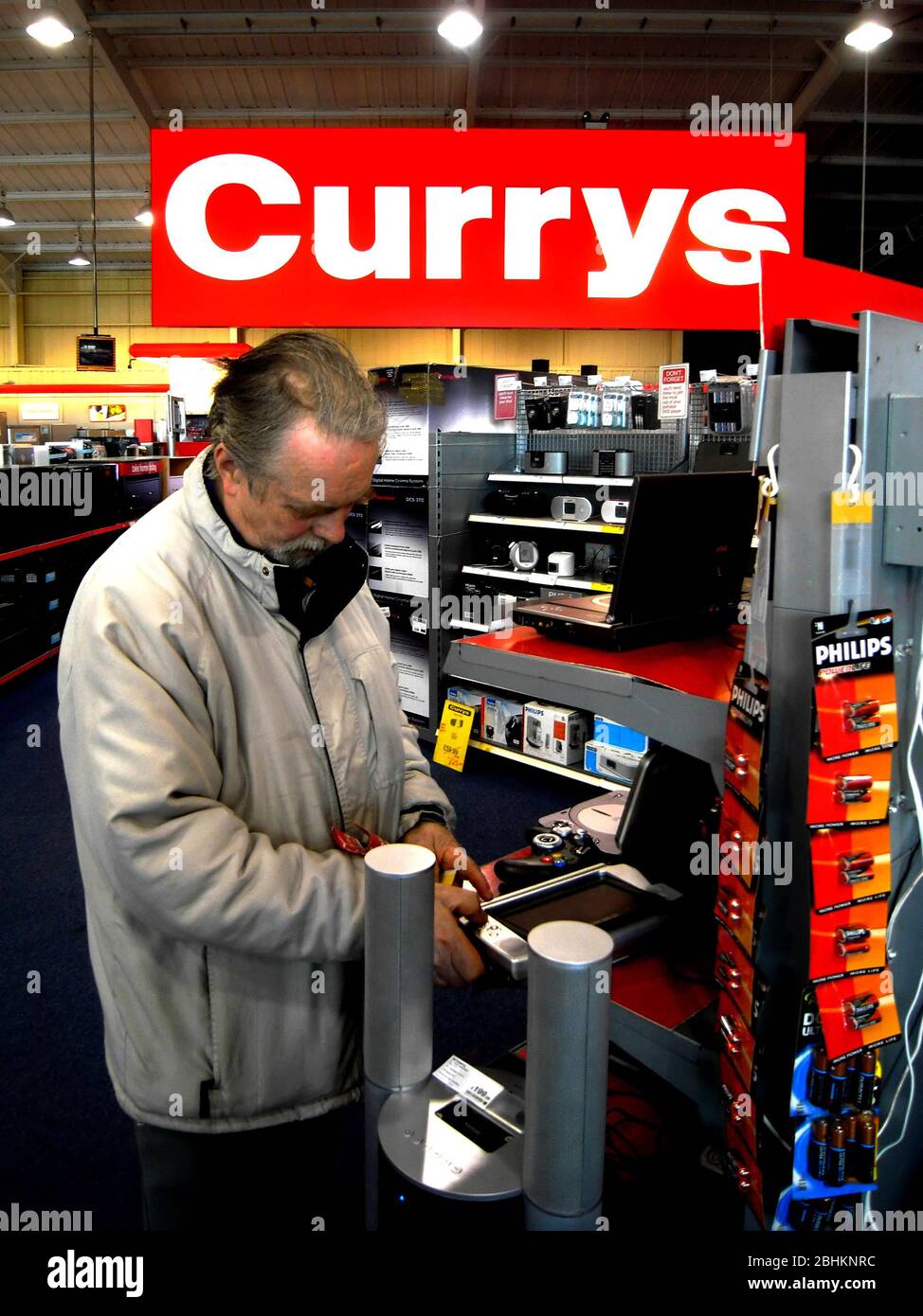 Un cliente latop Currys explorando el área y electrónica móvil dentro de una tienda. Foto de stock