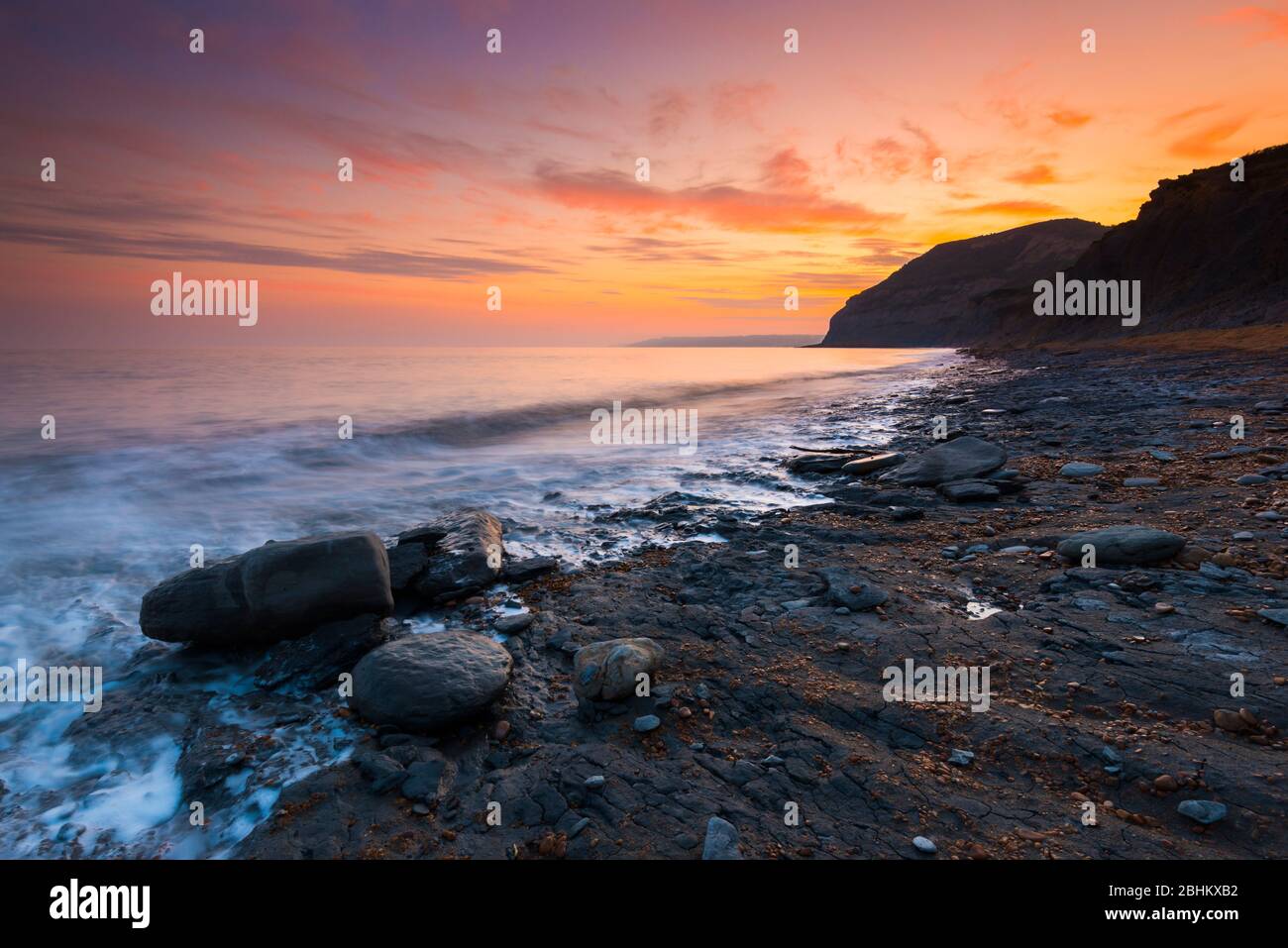 Seatown, Dorset, Reino Unido. 26 de abril de 2020. Clima en Reino Unido. Las nubes brillan de naranja al atardecer en Seatown en Dorset mirando hacia el oeste hacia los acantilados de Golden Cap. Crédito de la imagen: Graham Hunt/Alamy Live News Foto de stock