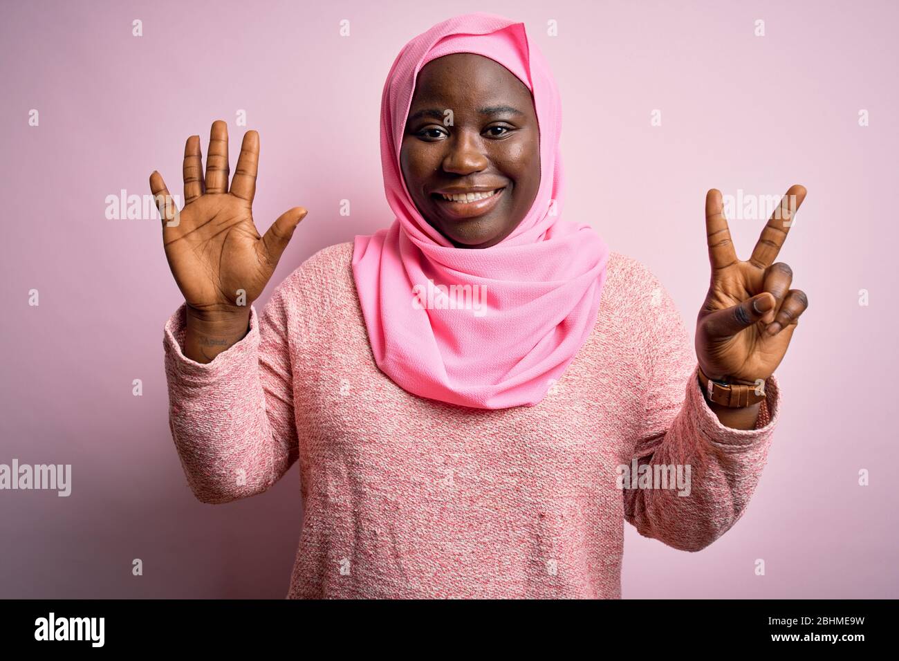 Joven Afroamericano Más Tamaño Mujer Que Lleva El Hijab Musulmán Sobre Fondo Rosado Aislado 
