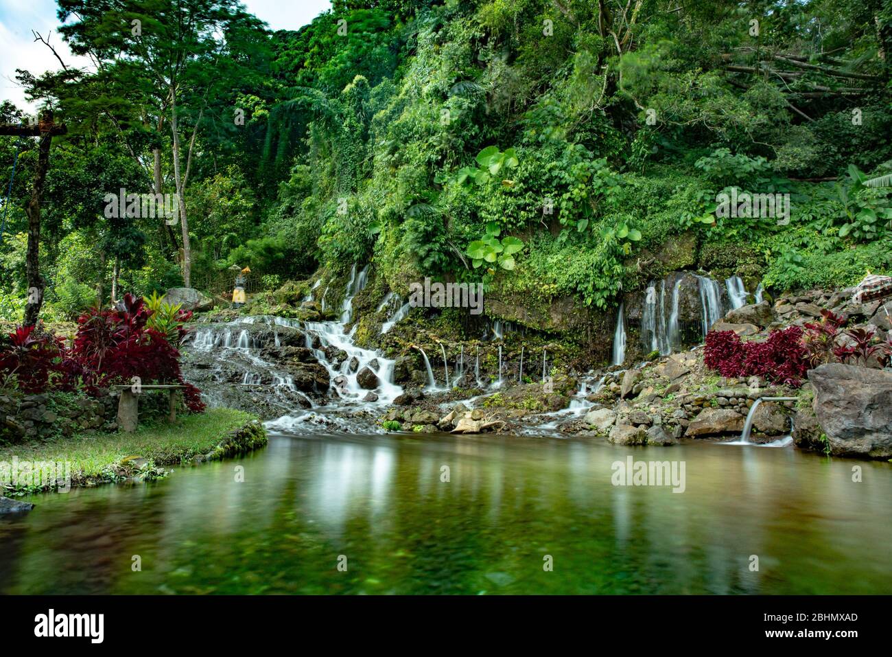 Agua fresca y fría en las colinas de Bali persiguiendo cascadas a través de la exuberante selva tropical Foto de stock