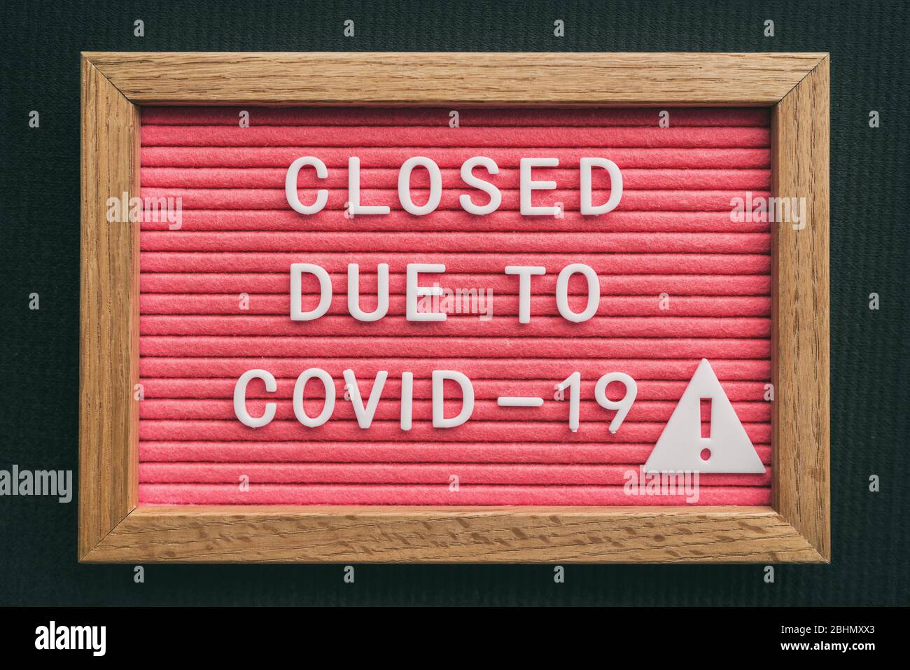 Signo de cierre de almacén de coronavirus. Cerrado debido al tablón de mensajes COVID-19 para el negocio minorista brote pandémico COVID-19. Cierre gubernamental de restaurantes, panaderías, servicios no esenciales. Letras rosas. Foto de stock