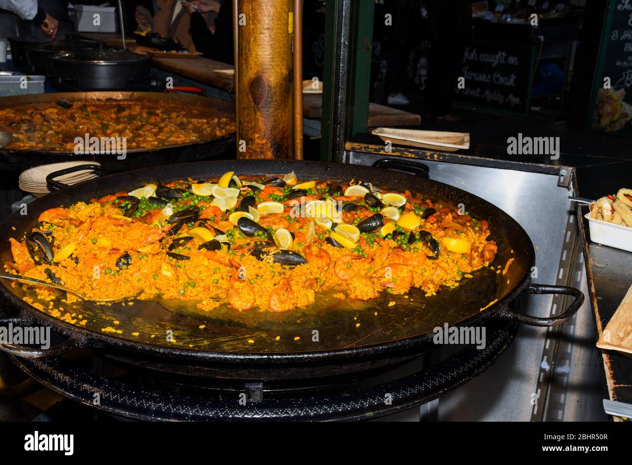 Paella de mariscos cocidos en una gran sartén wok, festival de comida de la  calle. Especialidad de platos de día nacional de la fiesta mexicana.  Estación de cocina en vivo. Buffet de