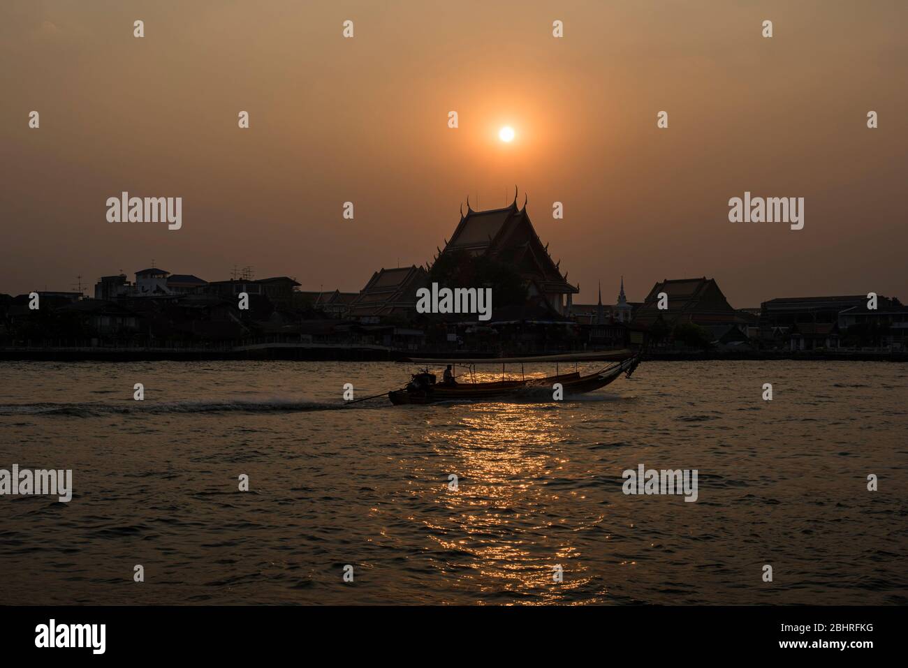 Una larga cola de barco de crucero por el río Chao Phraya durante la puesta de sol, Bangkok, Tailandia. Foto de stock