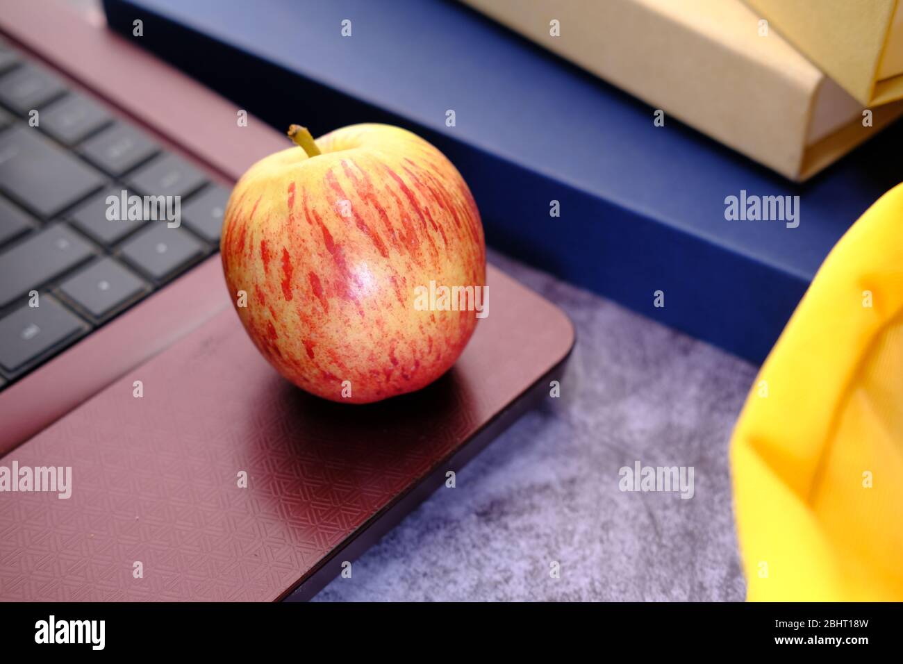 concepto de vuelta a la escuela con manzana y bolsa escolar sobre la mesa Foto de stock