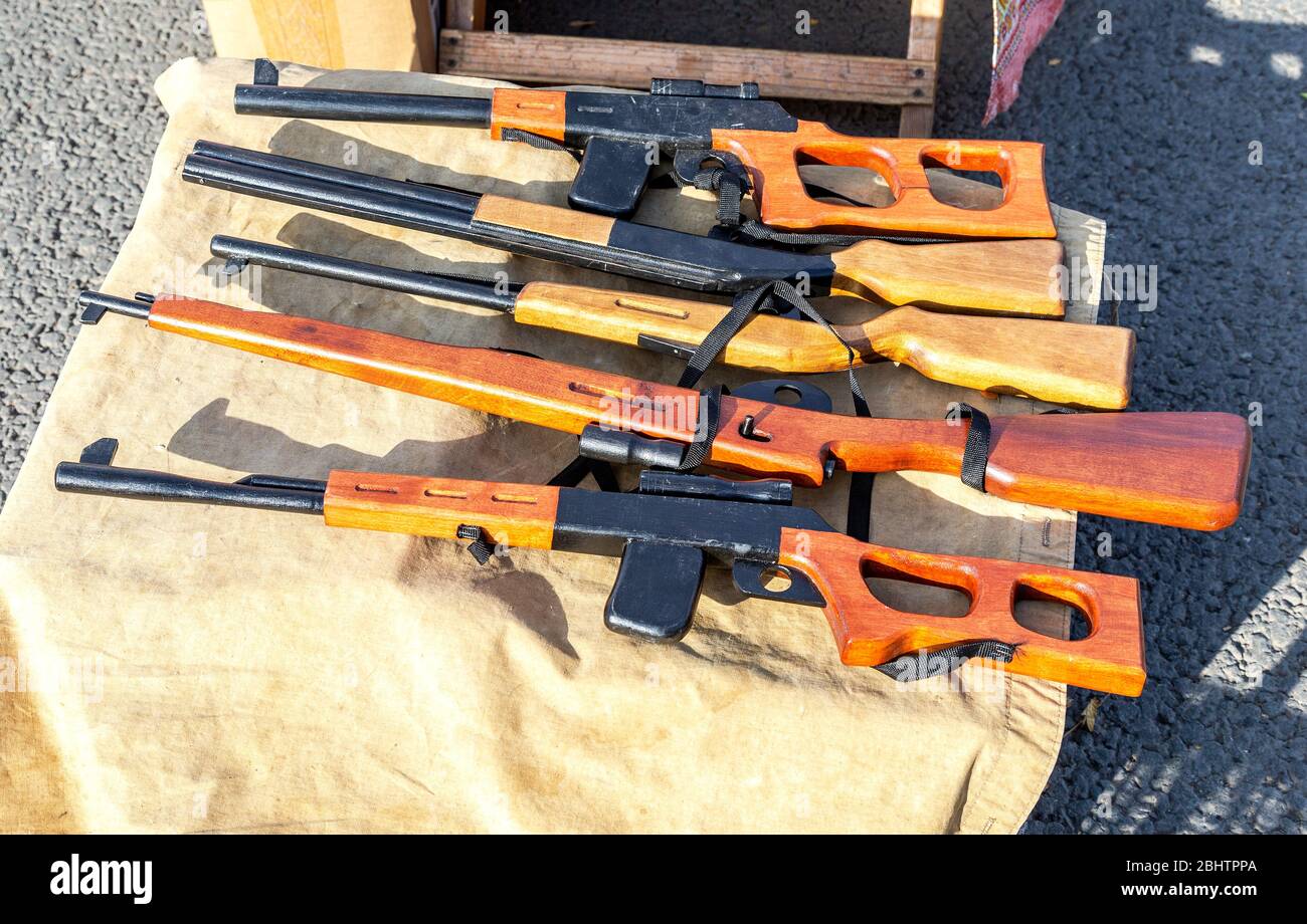 Diferentes rifles de juguete de madera hechos a mano, pistolas para niños  en el mostrador de la tienda de recuerdos en la feria de la calle  Fotografía de stock - Alamy