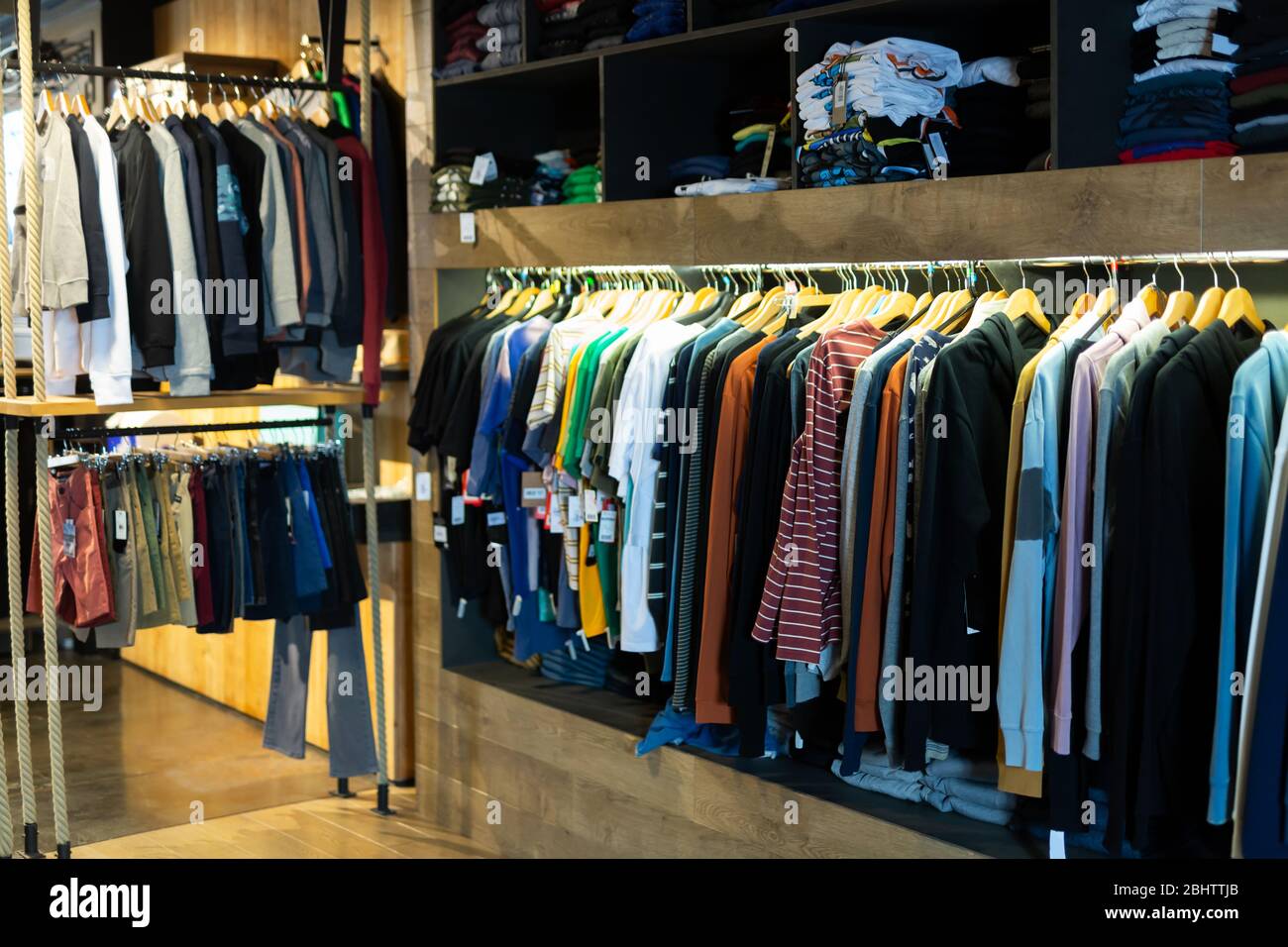 Tienda de ropa para hombres, variedad de ropa informal en perchas y  estantes en tienda de ropa Fotografía de stock - Alamy