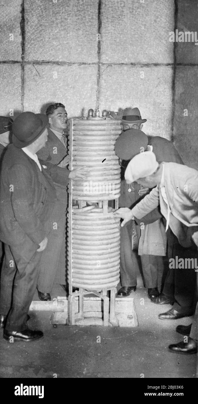 Los refrigeradores mantienen las manzanas en condiciones. - equipado con refrigeradores gigantes y todo el equipo más último, un gran almacén nuevo para las manzanas se ha construido en los huertos extensos un Cockayne Hatley, Potton, Bedfordshire. En el almacén, que puede mantenerse a una temperatura uniforme, muchas toneladas de manzanas pueden mantenerse hasta que se requieran. - Fotos: Inspección de uno de los grandes refrigeradores en la nueva tienda de manzanas. - 18 de septiembre de 1936 Foto de stock