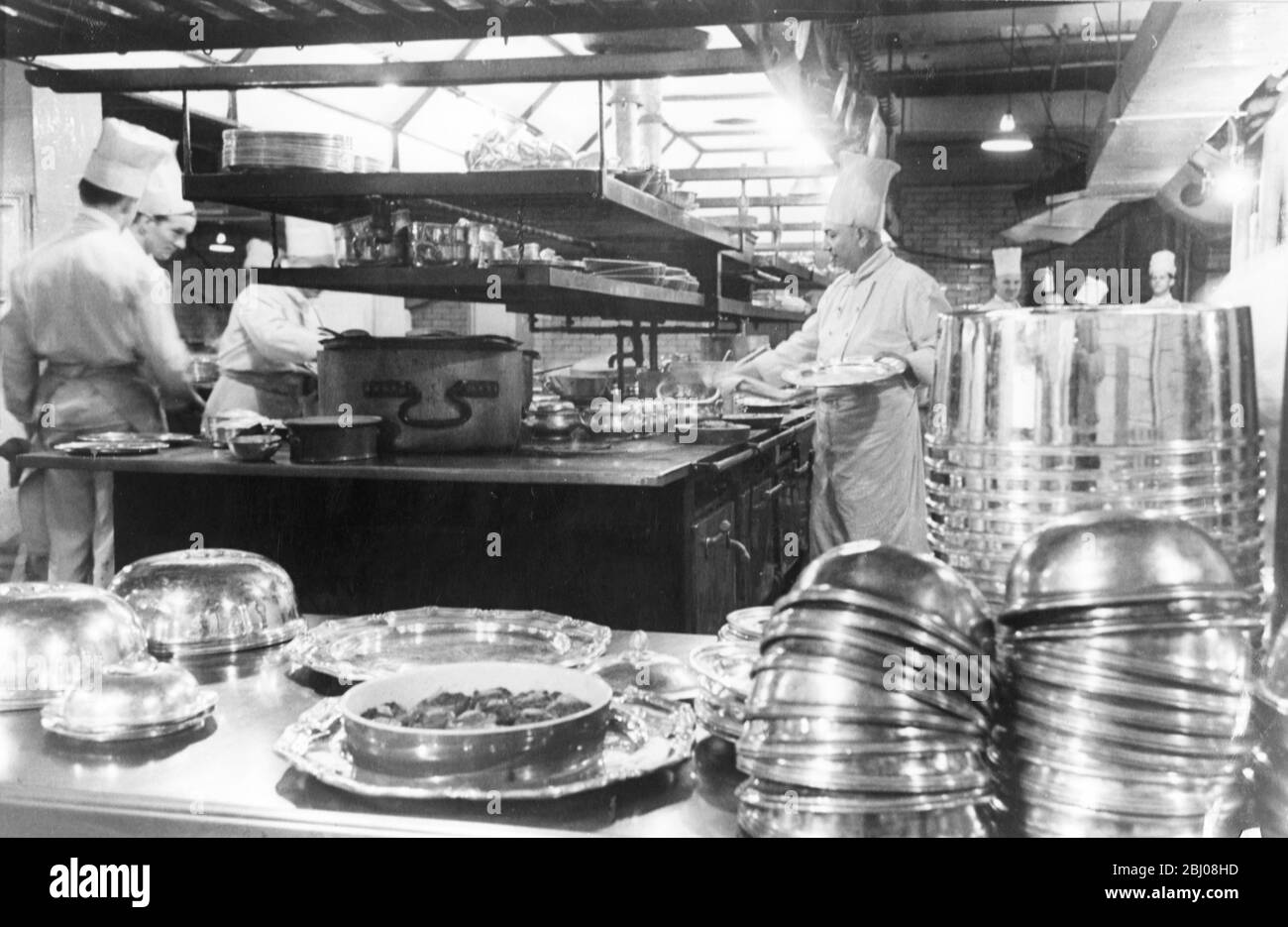 Famoso chef francés Maitre de cocina, M.A. Alban en la cocina a la parrilla en el hotel Savoy con miembros del personal de cocina grande. - 19 de febrero de 1948 Foto de stock