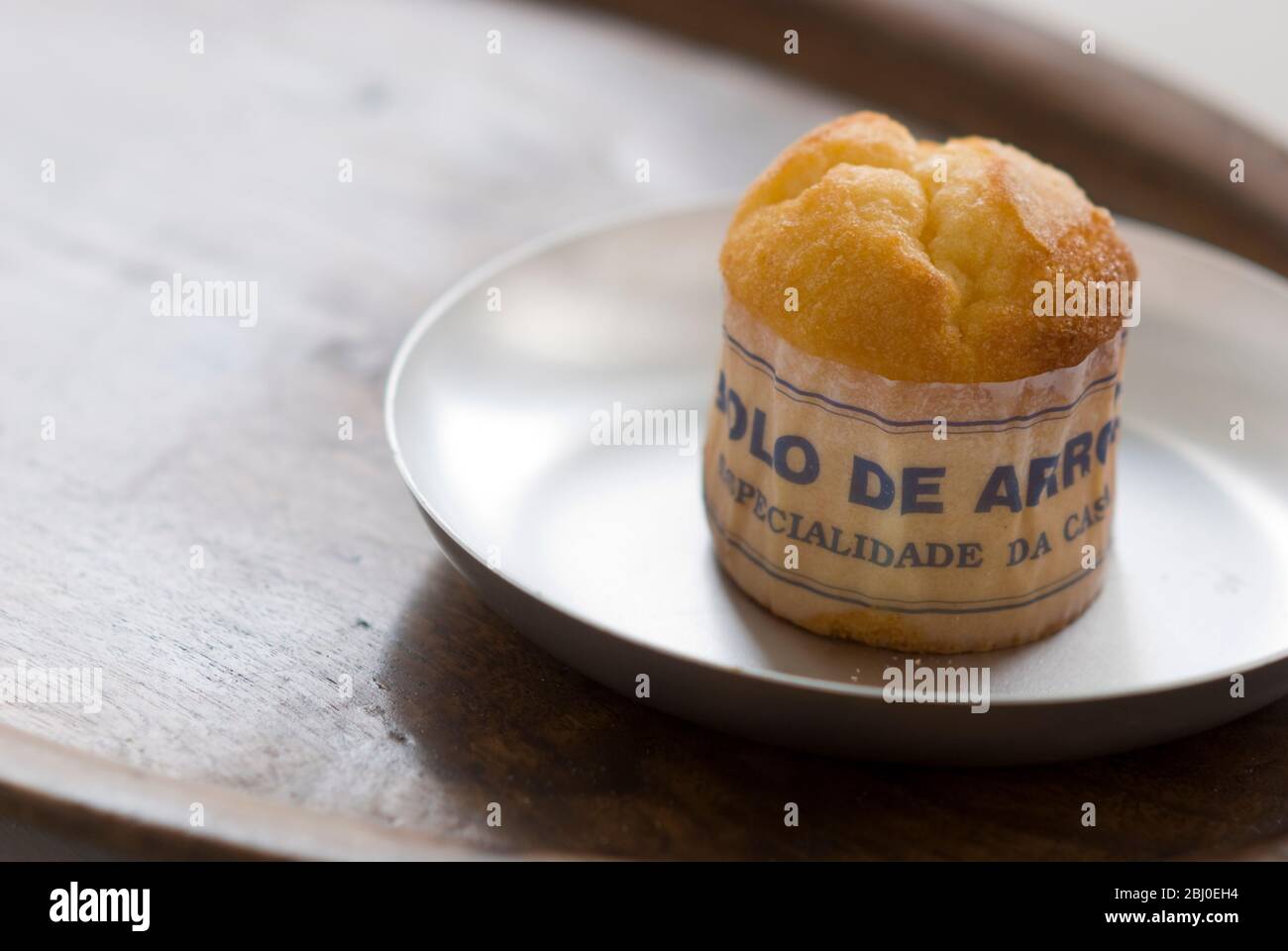 Pastel de muffin portugués clásico hecho con arroz en papel sobre plato de metal, con taza de café negro - Foto de stock