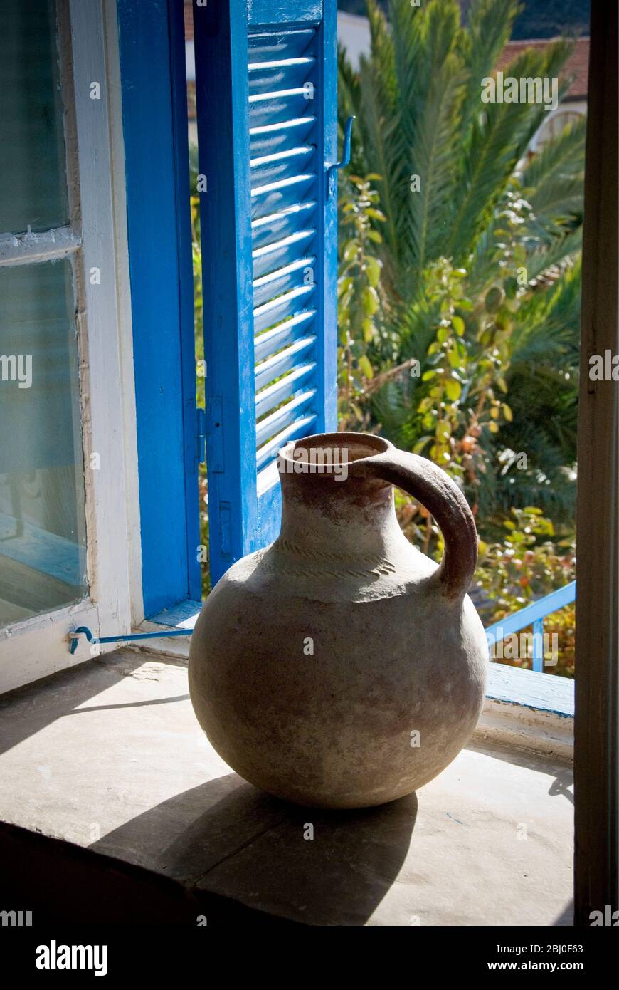 Una gran jarra de barro en el alféizar de la ventana de una casa chipriota en el sur (griego) Chipre - Foto de stock