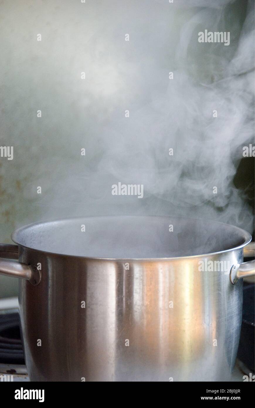 Vapor de agua hirviendo en una cacerola de acero inoxidable en la placa - Foto de stock