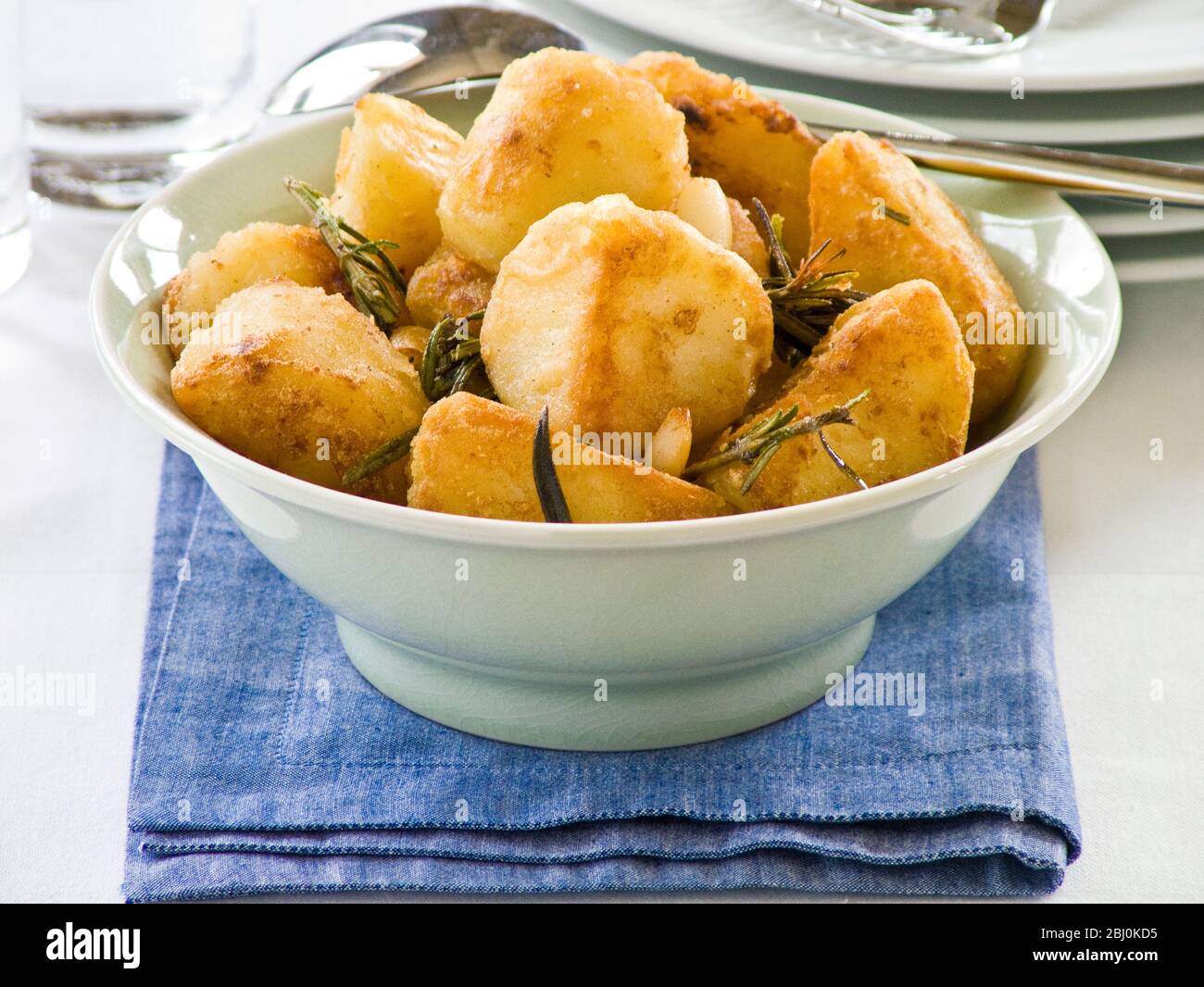 Patatas asadas con romero en un tazón verde - Foto de stock