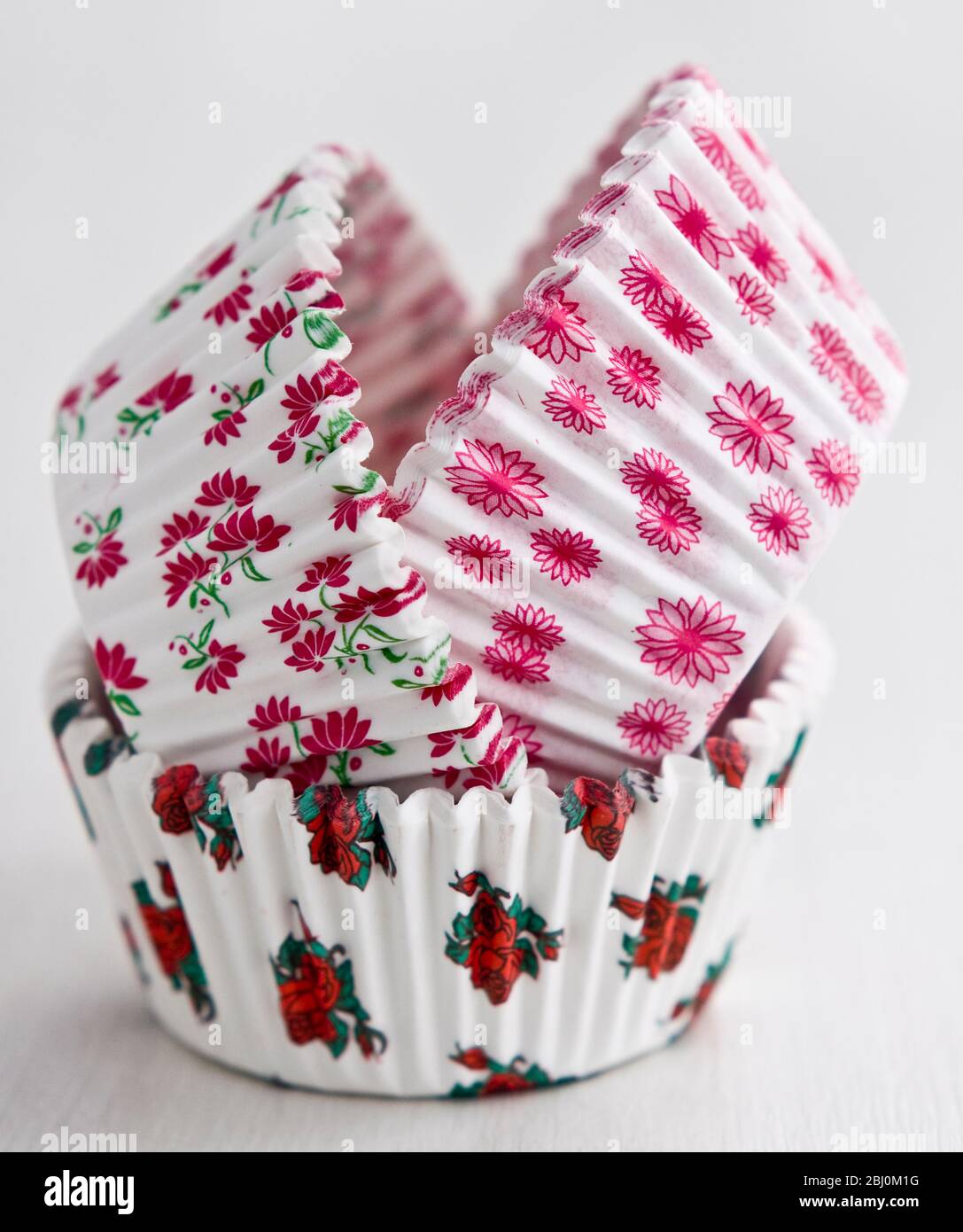 Pila de papel decorativo de flores de pastel y muffin cajas - Foto de stock