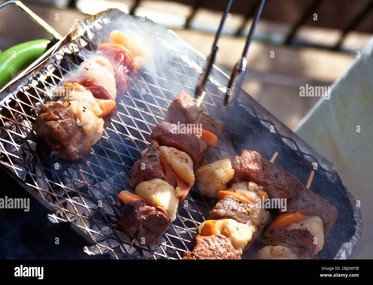 Parrilla de vieiras y kebabs de bistec en una parrilla de carbón. Foto de stock