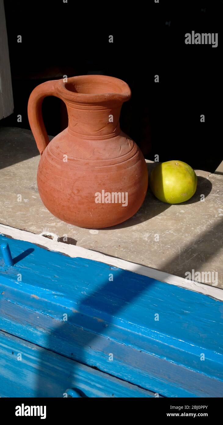Cerámica tradicional, jarra, y limón en el alféizar de la ventana de la casa en Chipre - Foto de stock