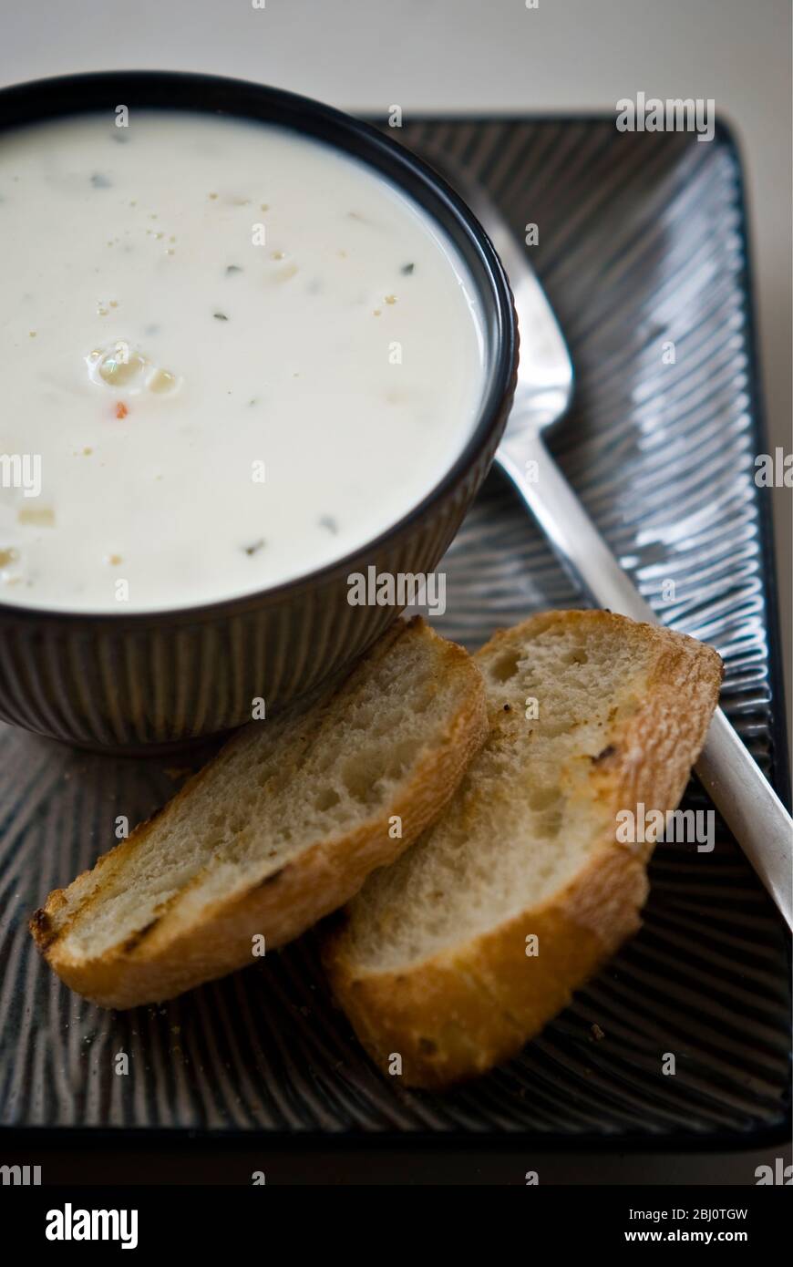 Mejillón, marisco y sopa de salmón ahumado en un cuenco de cerámica con pan a la parrilla - Foto de stock